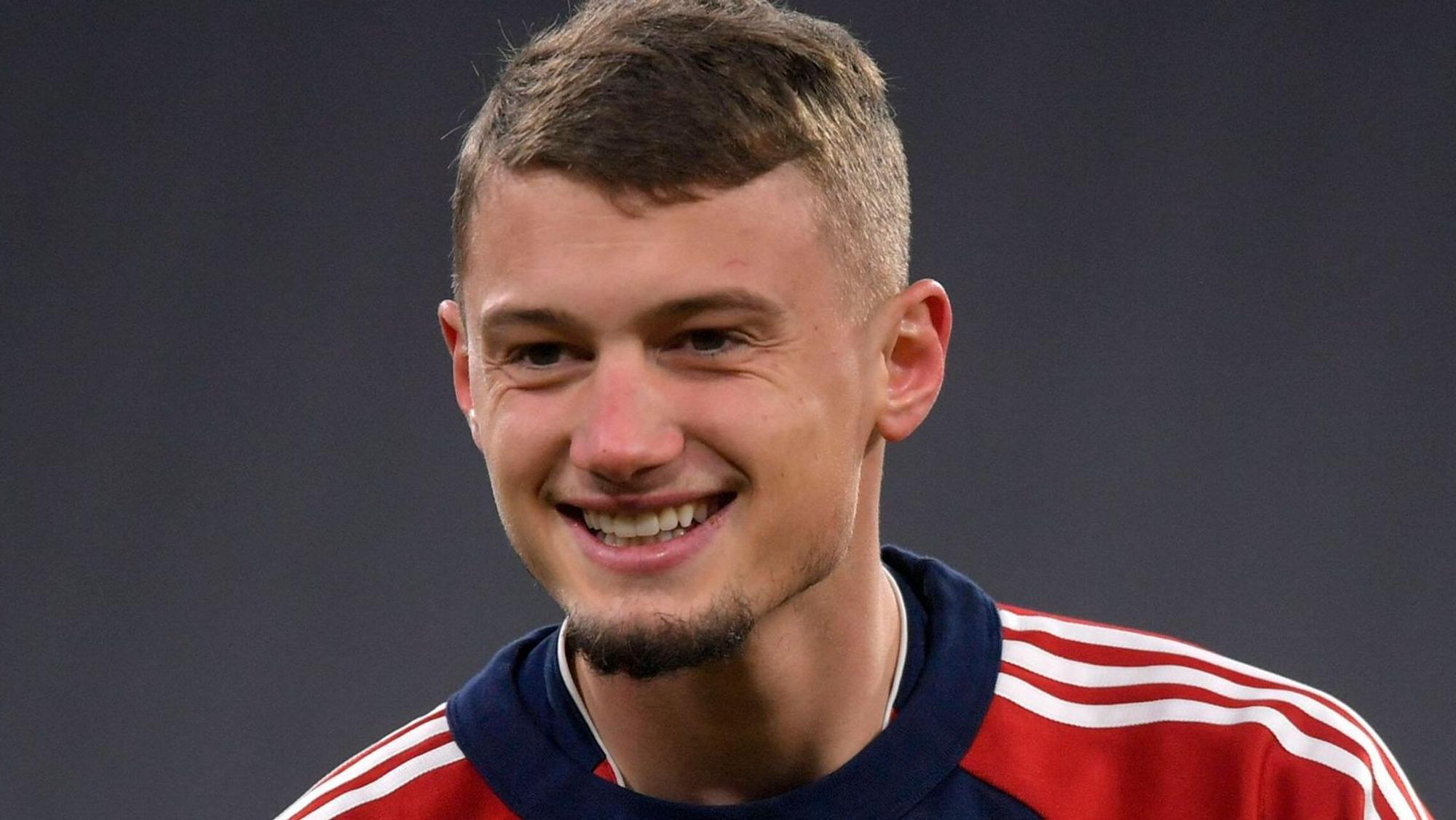 Michael Cuisance lächelt am 17. Dezember 2021 beim Spiel des FC Bayern gegen den VfL Wolfsburg.