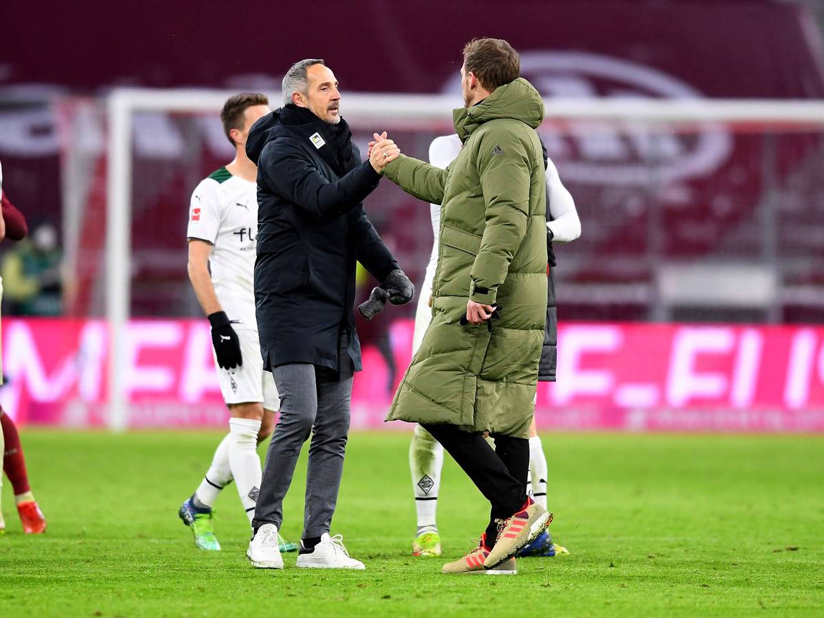 Gladbach-Trainer Adi Hütter (l.) klatscht zum Rückrundenauftakt (7. Januar 2022) in der Allianz-Arena Bayern-München-Coach Julian Nagelsmann (r.) ab. Beide Trainer tragen warme Jacken.