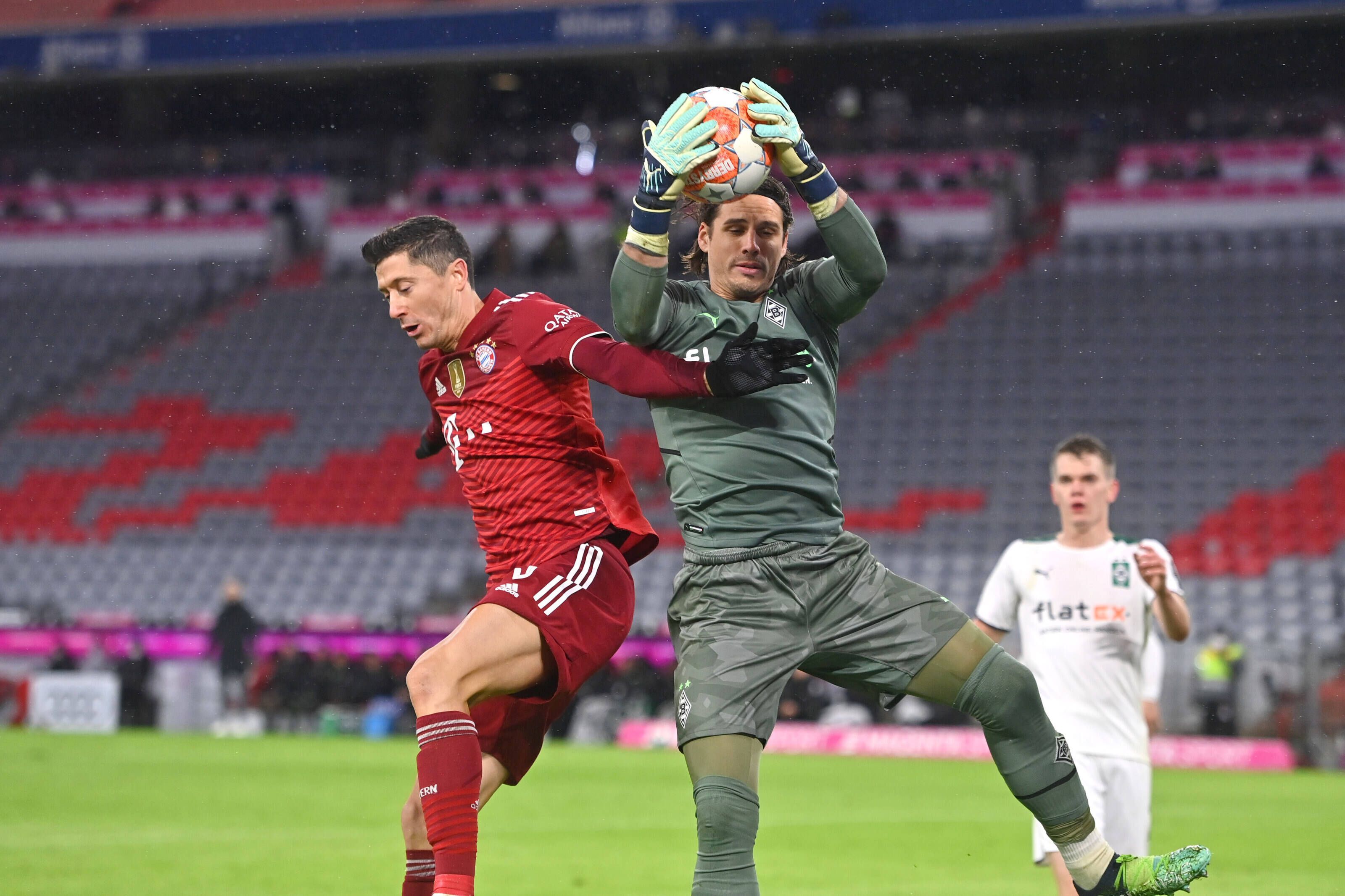Yann Sommer (r.), Torhüter von Borussia Mönchengladbach, hält auch in dieser Szene gegen Bayern-München-Stürmer Robert Lewandowski (l.) den Rückrunden-Auftakt-Sieg (7. Januar 2022) der Fohlen-Elf in der Allianz-Arena fest.  Im Hintergrund schaut Borussias Verteidiger Matthias Ginter gebannt zu.