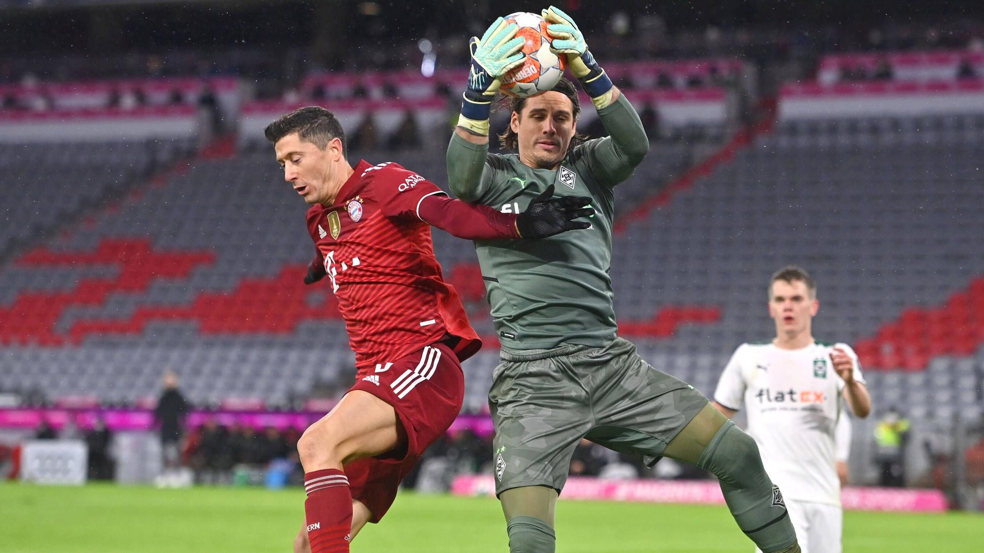 Yann Sommer (r.), Torhüter von Borussia Mönchengladbach, hält auch in dieser Szene gegen Bayern-München-Stürmer Robert Lewandowski (l.) den Rückrunden-Auftakt-Sieg (7. Januar 2022) der Fohlen-Elf in der Allianz-Arena fest. Im Hintergrund schaut Borussias Verteidiger Matthias Ginter gebannt zu.