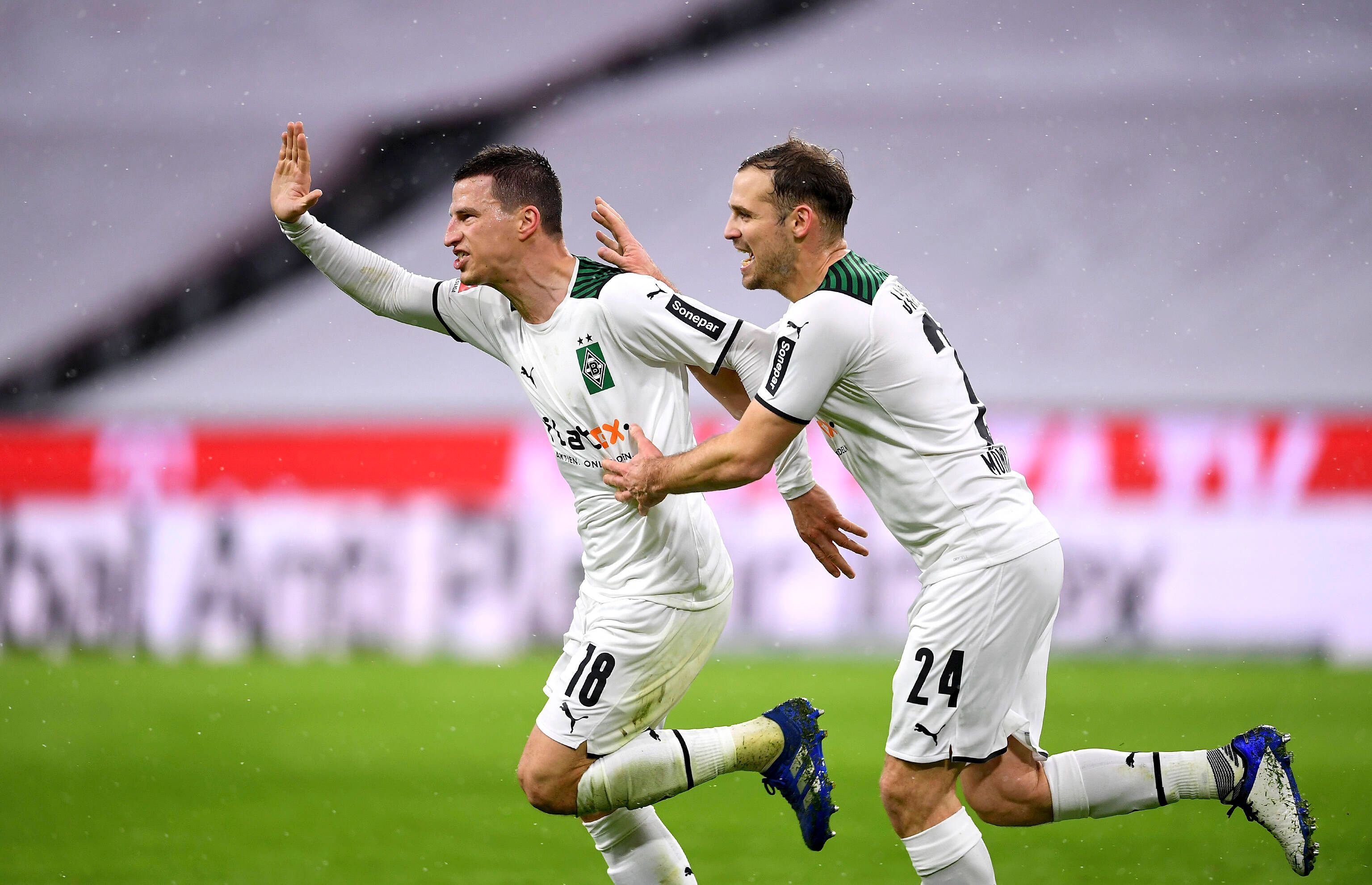 So sehen Sieger aus! Die Borussia-Mönchengladbach-Profis Stefan Lainer (l.) und Tony Jantschke (r.) beim Jubellauf während des Rückrunden-Sieges (7. Januar 2022) bei Bayern München in der Allianz-Arena. Lainer hebt den Arm voller Freude, Jantschke läuft und jubelt mit.