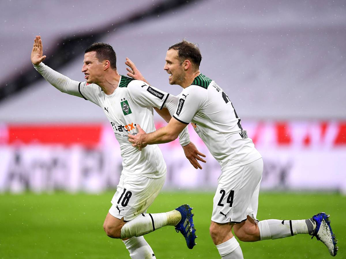 So sehen Sieger aus! Die Borussia-Mönchengladbach-Profis Stefan Lainer (l.) und Tony Jantschke (r.) beim Jubellauf während des Rückrunden-Sieges (7. Januar 2022) bei Bayern München in der Allianz-Arena. Lainer hebt den Arm voller Freude, Jantschke läuft und jubelt mit.