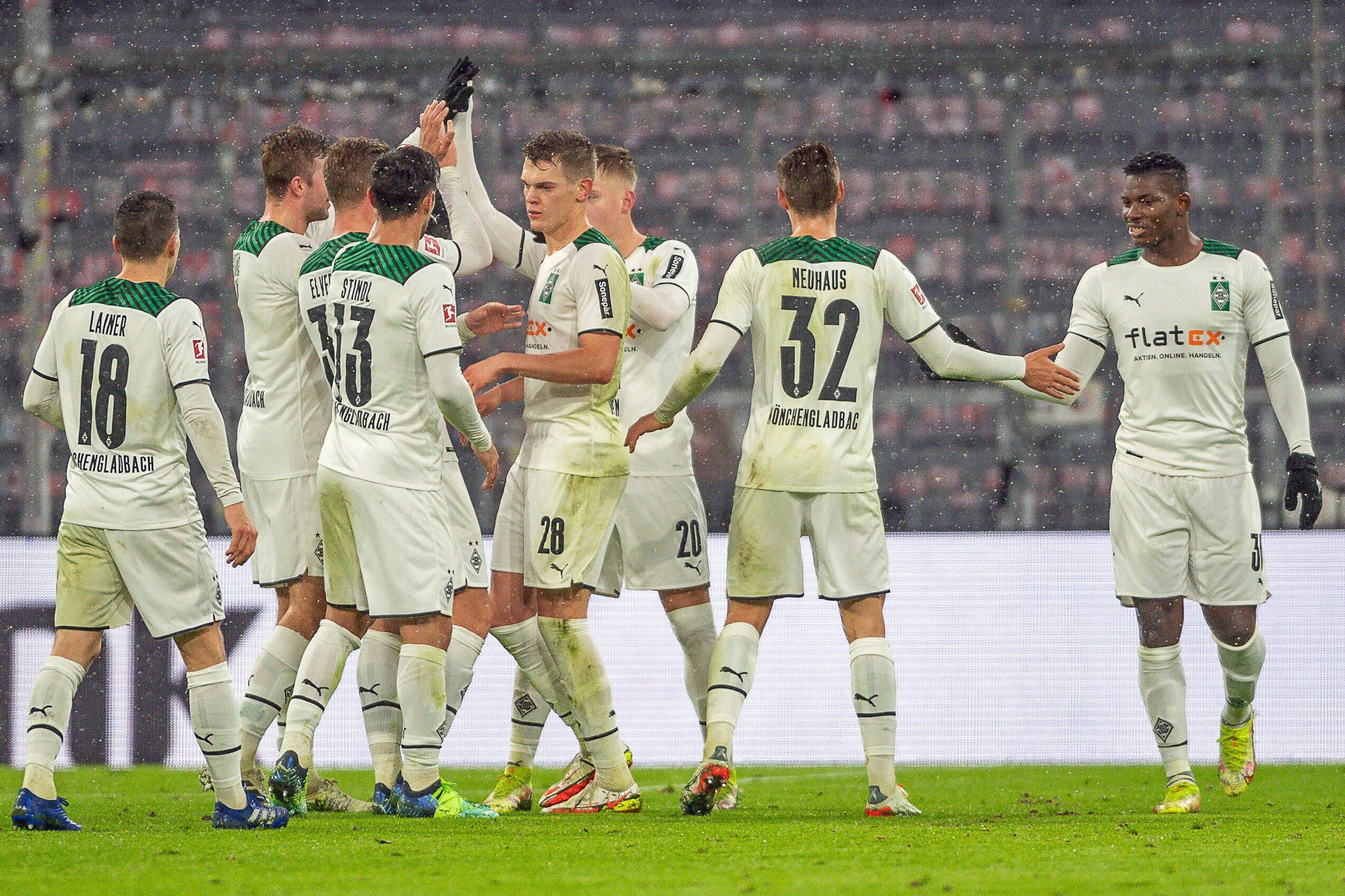 Spieler von Borussia Mönchengladbach klatschen sich beim Rückrunden-Auftaktsieg bei Bayern München (7. Januar 2022) in der Allianz-Arena ab. Zu sehen sind Profis wie Matthias Ginter, Florian Neuhaus oder Stefan Lainer.