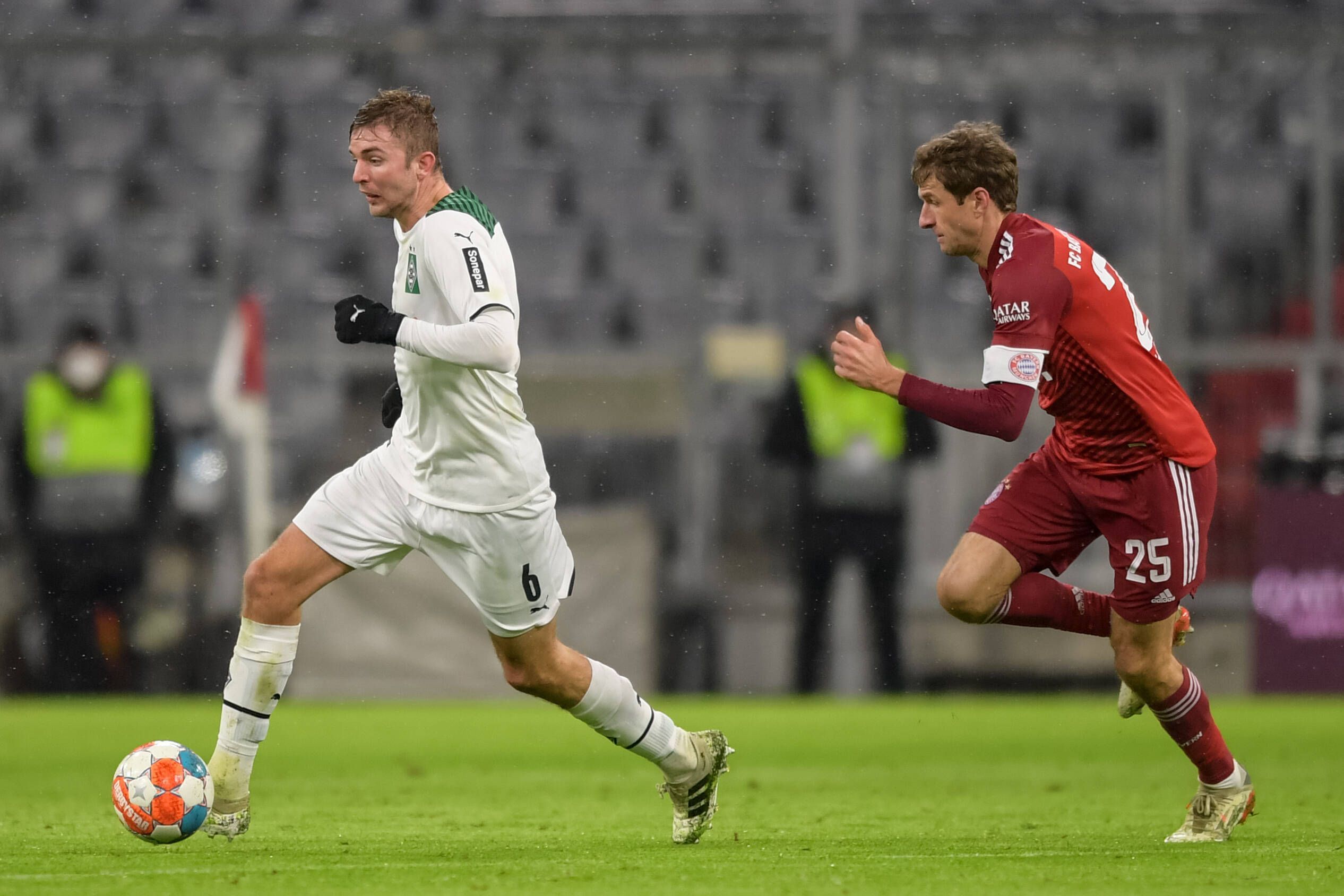 Borussias Mittelfeldspieler Christoph Kramer (l.), Weltmeister von 2014, im Duell mit Weltmeister und Bayern-München-Star Thomas Müller am 7. Januar 2022 in der Allianz-Arena. Kramer läuft mit dem Ball und wird von Müller gejagt.