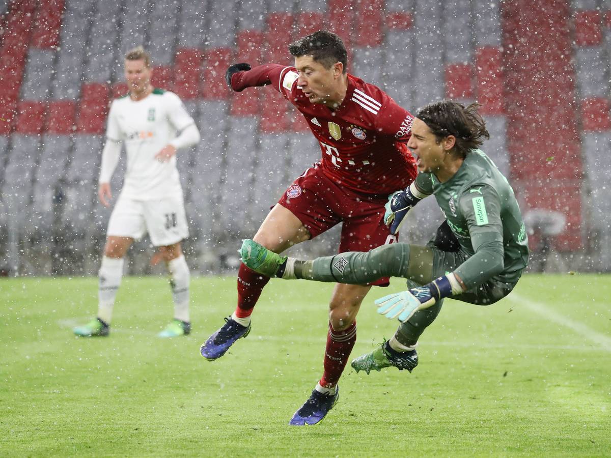 Borussia-Mönchengladbach-Torhüter Yann Sommer (r.) im Zweikampf mit Robert Lewandowski (M.9, Stürmer von Bayern München, während des Bundesliga-Duells am 7. Januar 2022 in der Allianz-Arena. Sommer schreibt und fällt zu Boden.