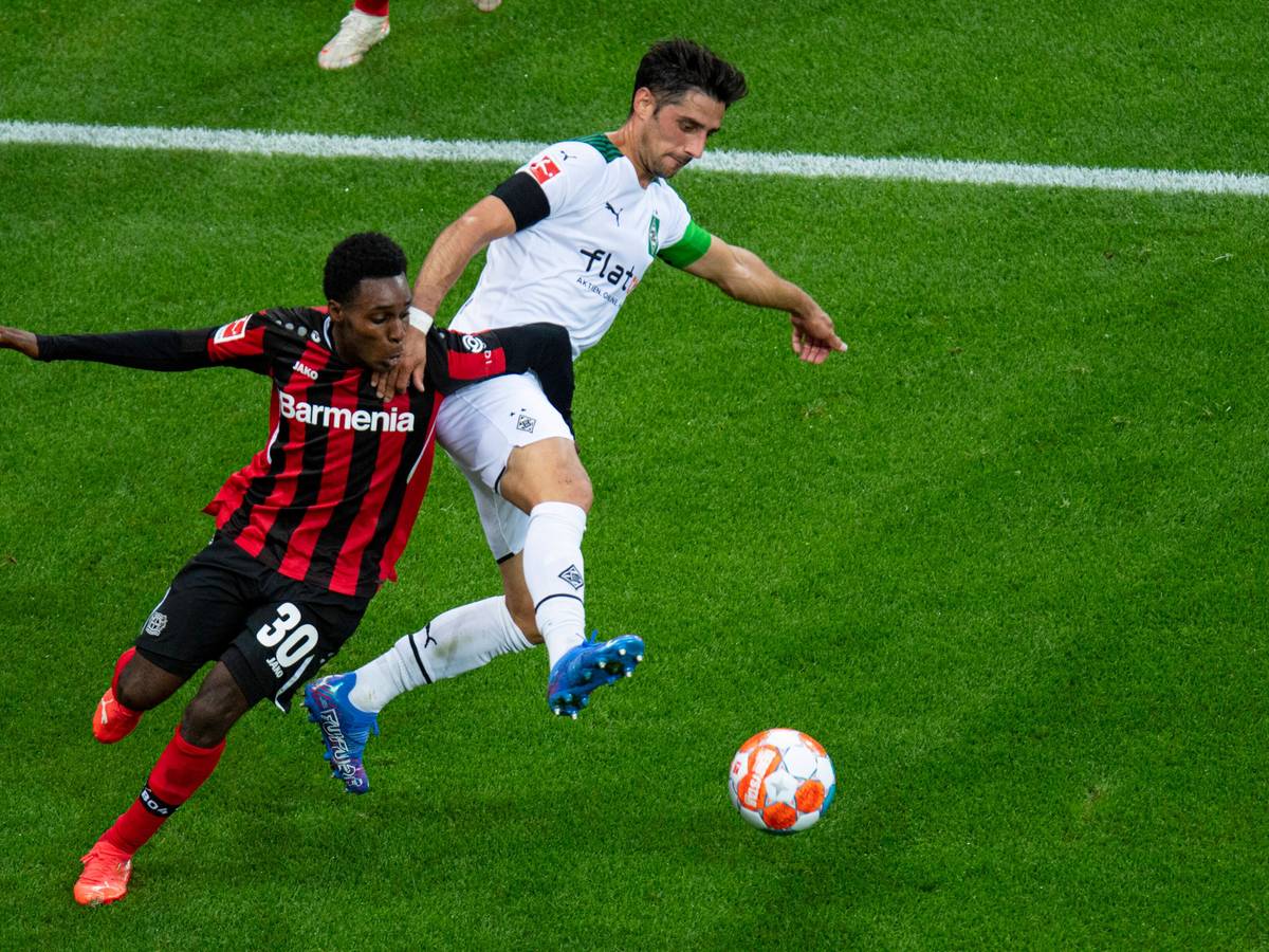 Lars Stindl (r.) von Borussia Mönchengladbach im Duell um den Ball mit Jeremie Frimpong von Bayer Leverkusen beim Bundesliga-Hinrundenspiel am 21. August 2021.
