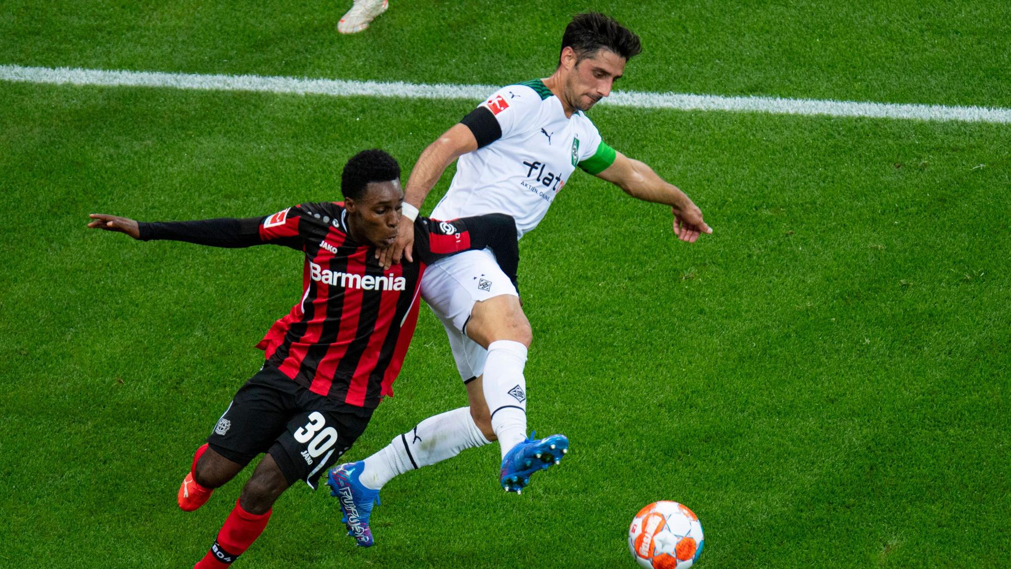 Lars Stindl (r.) von Borussia Mönchengladbach im Duell um den Ball mit Jeremie Frimpong von Bayer Leverkusen beim Bundesliga-Hinrundenspiel am 21. August 2021.