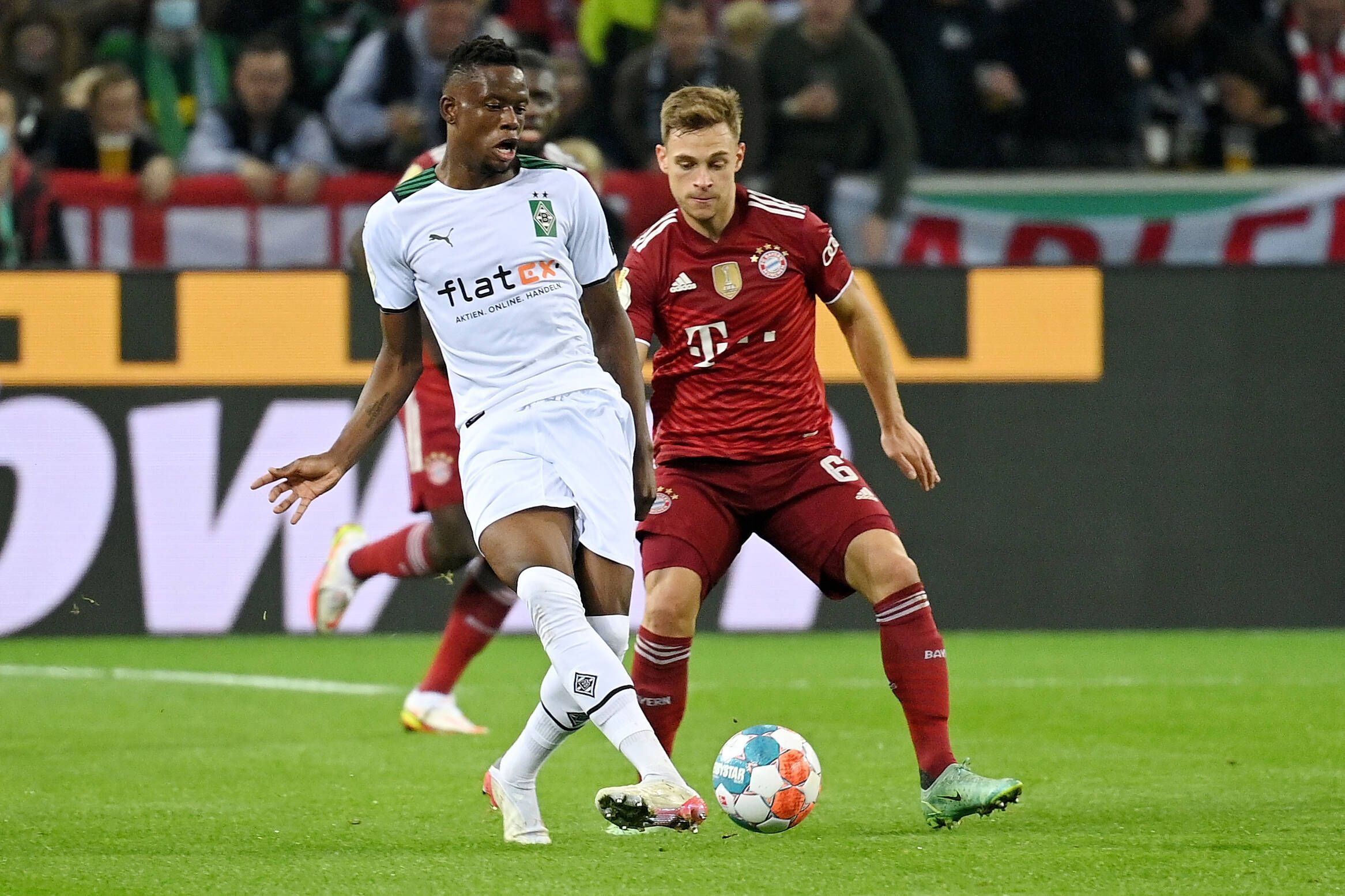 Mittelfeldspieler Denis Zakaria (l.) von Borussia Mönchengladbach im Duell mit Joshua Kimmich (r.) von Bayern München während des DFB-Pokalspiels am 27. Oktober 2021 im Borussia-Park. Zakaria spielt mit dem rechten Fuß den Ball.