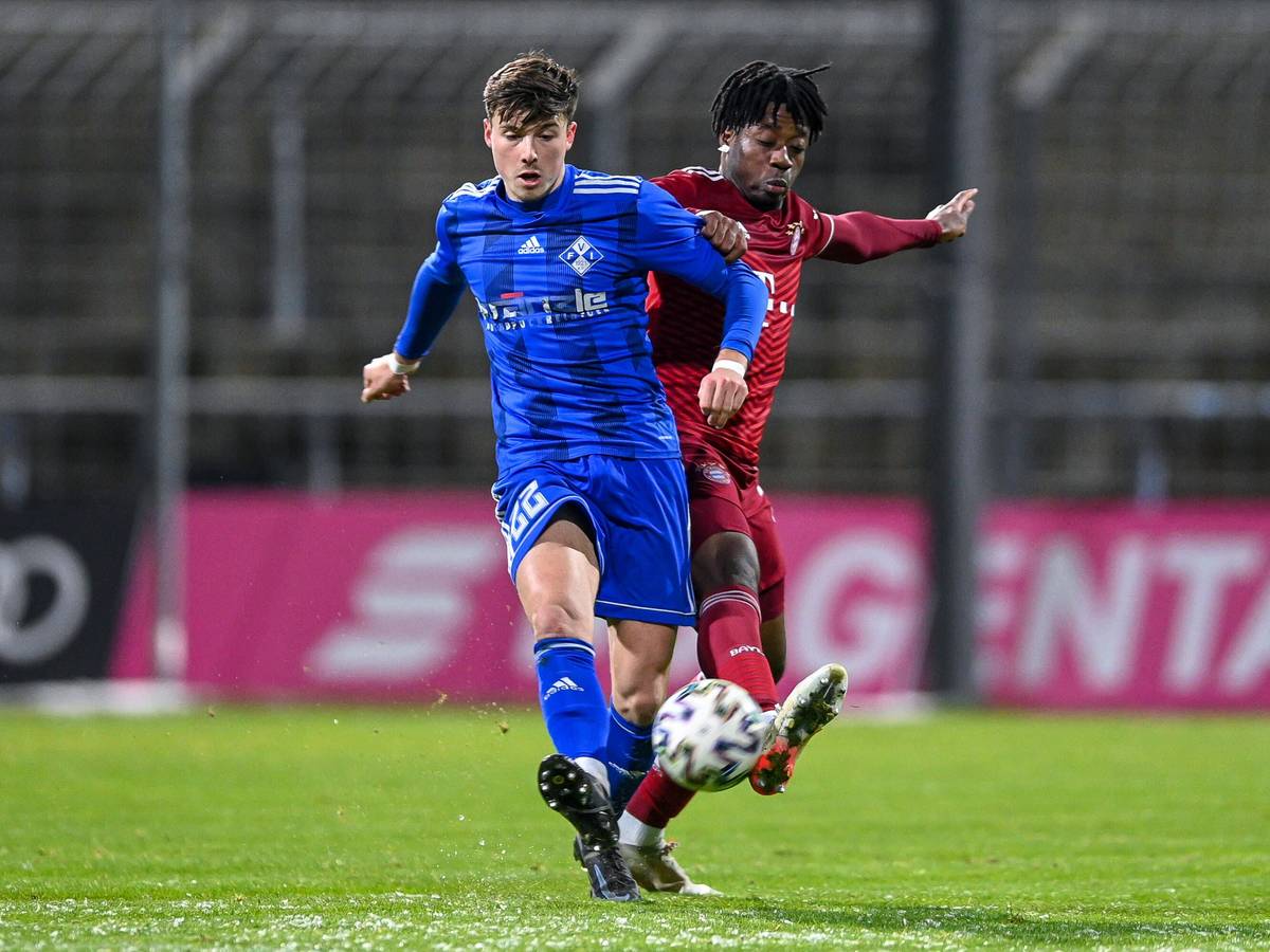 Semir Telalovic (l.) von FV Illertissen, hier am 3. Dezember 2021 in der Regionalliga Bayern im Duell mit Bright Akwo Arrey-Mbi (r.) von Bayern München II, steht vor einem Wechsel zu Borussia Mönchengladbach. Telalovic schießt den Ball nach vorne.
