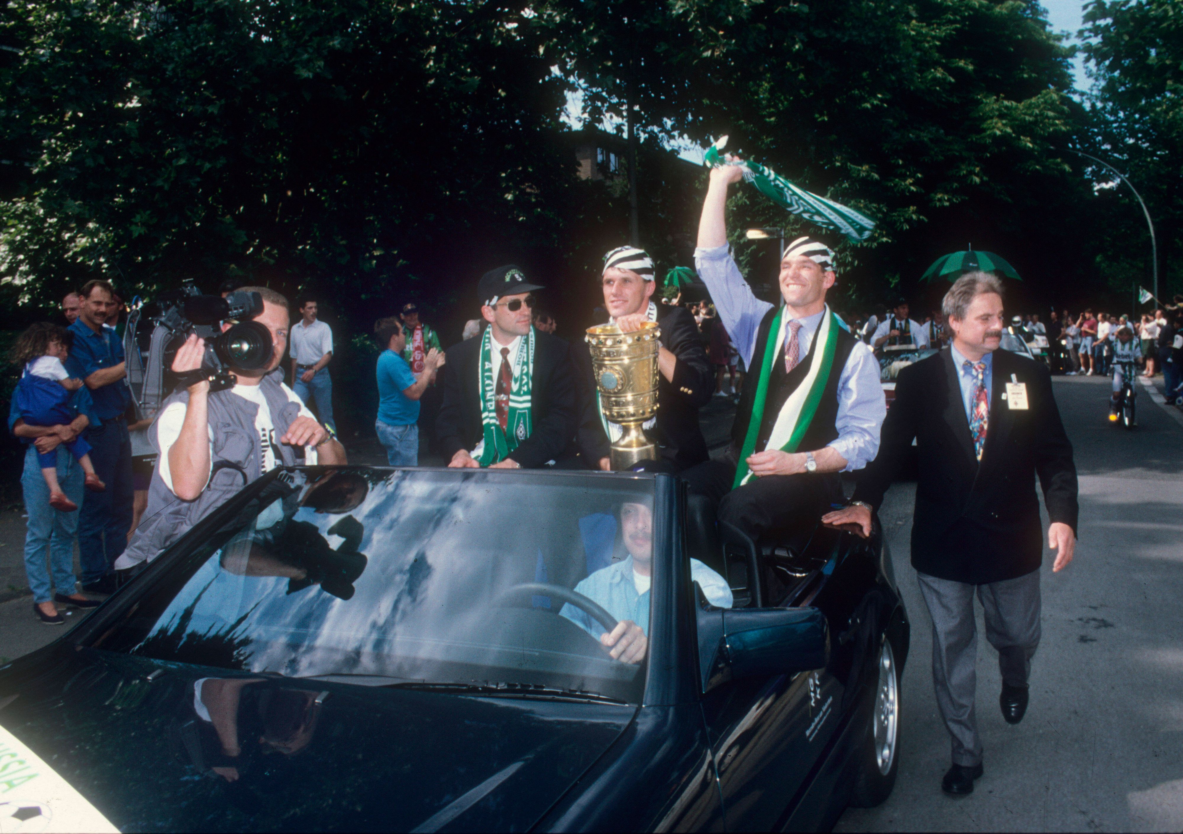 Die Borussia-Spieler (von links) Christian Hochstätter, Michael Klinkert und Uwe Kamps im Cabriolet mit DFB-Pokal am 25. Juni 1995 in Mönchengladbach.