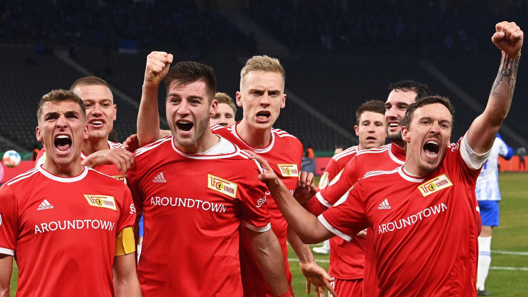 Die Spieler von Union Berlin bejubeln am 19. Januar 2022 den Sieg im DFB-Pokal-Duell bei Hertha BSC: (v.l.) Grischa Prömel, Julian Ryerson, Robin Knoche, Timo Baumgartl, Levin Öztunali und der ehemalige Gladbacher Max Kruse. Kruse schreit seine Freude heraus.