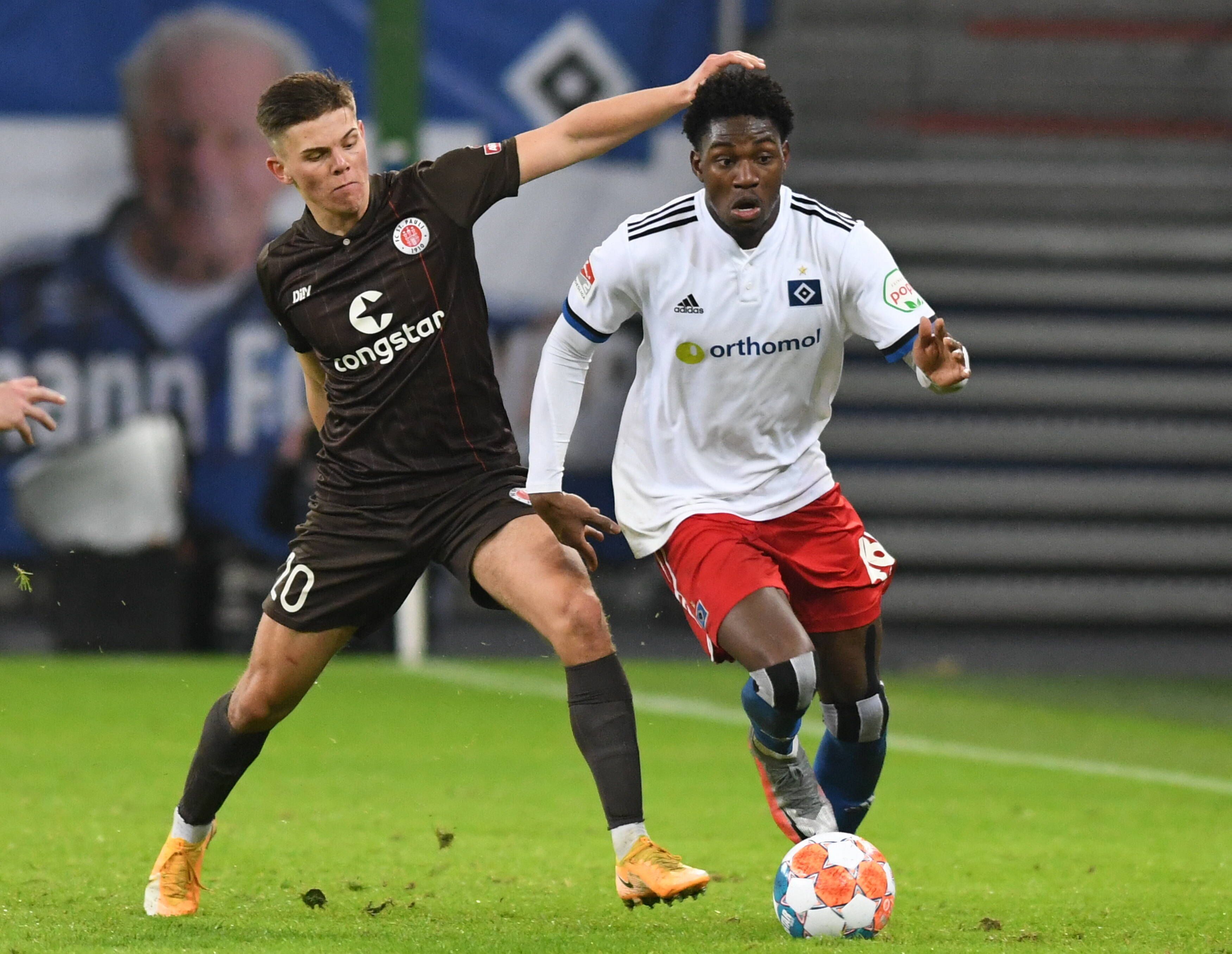 Finn Ole Becker vom FC St. Pauli, hier am 21. Januar 2022 in Hamburg im Zweitliga-Duell mit HSV-Spieler Faride Alidou, soll bei Borussia Mönchengladbach ein Thema sein. Die beiden Spieler kämpfen um den Ball.