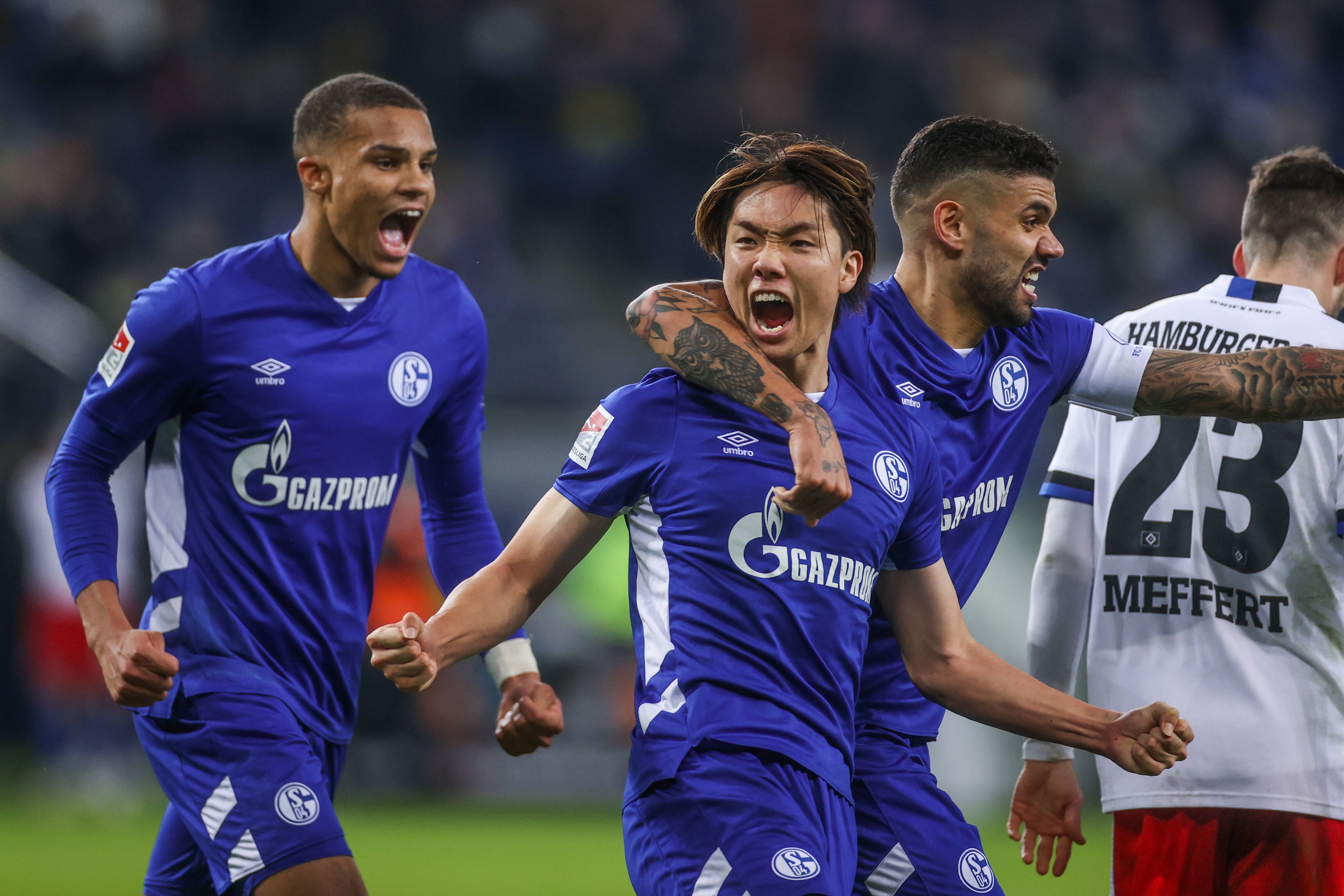 Ko Itakura (M.) jubelt im Trikot des FC Schalke am 18. Dezember 2021 über einen Treffer im Zweitliga-Duell gegen den Hamburger SV. Itakura schreit seine Freude heraus.