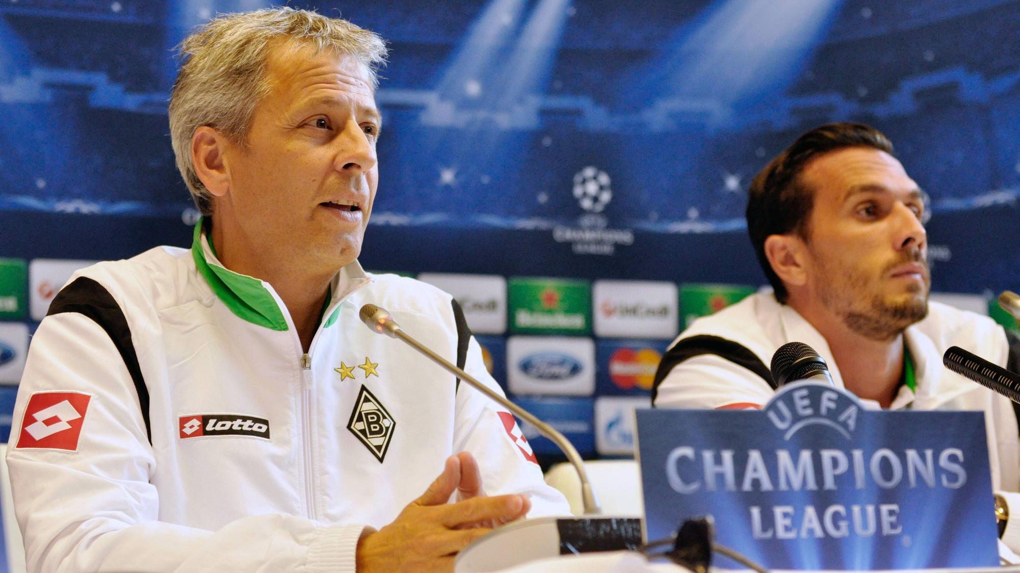 Ex-Gladbach-Kapitän Martin Stranzl (r.) und Ex-Borussia-Trainer Lucien Favre (l.) am 28. August 2012 bei einer Pressekonferenz vor dem Playoff-Duell zur UEFA Champions League gegen Dynamo Kiew in der Ukraine. Beide blicken in den Presseraum.