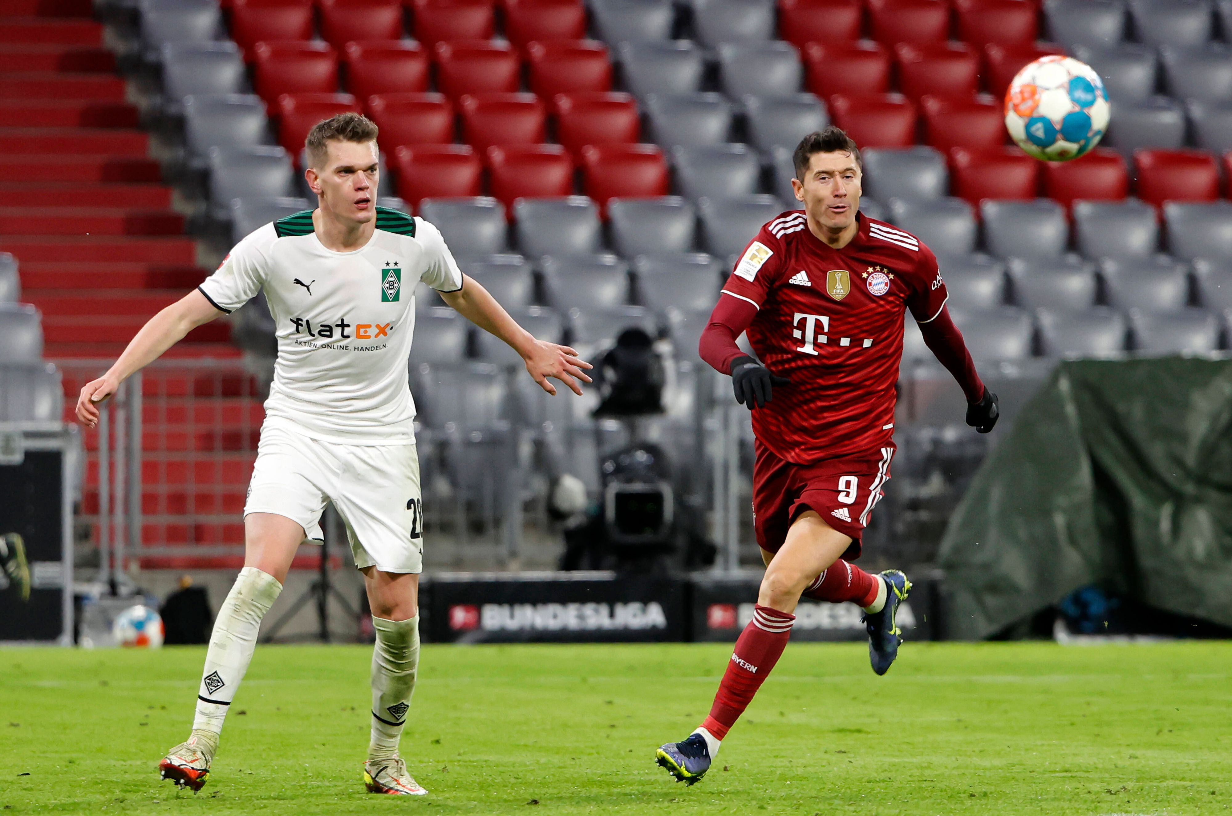 Gladbach-Verteidiger Matthias Ginter (l.) im Zweikampf mit Bayern-München-Stürmer Robert Lewandowski (r.) während des Bundesliga-Duells am 7. Januar 2022 in der Allianz-Arena. Beide Spieler haben den Ball im Blick.