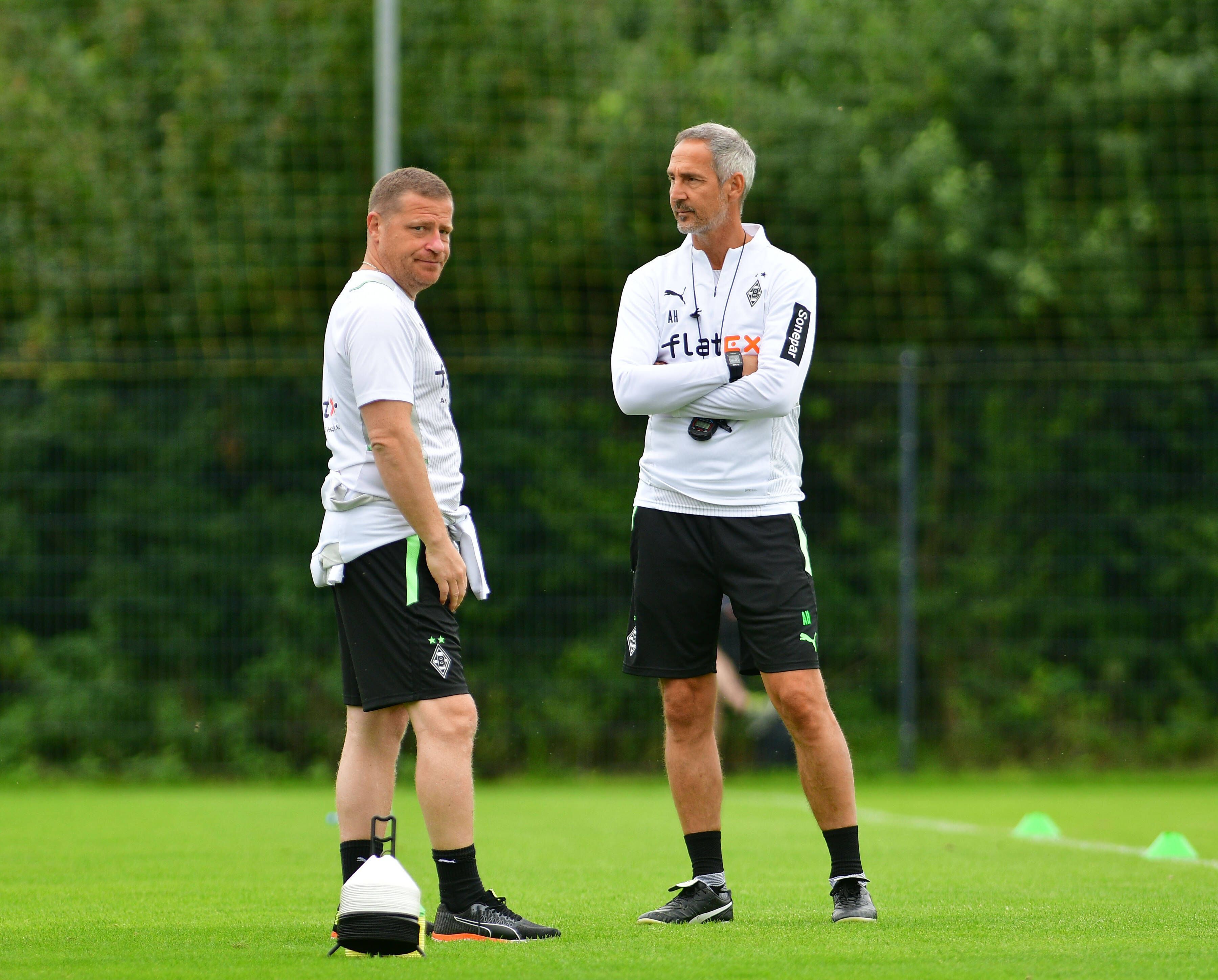 Ex-Sportdirektor Max Eberl (l.) und Gladbach-Trainer Adi Hütter (r.) unterhalten sich am 21. Juli 2021 im Trainingslager in Harsewinkel. Eberl schaut sichtlich genervt Richtung Fotografenkamera.