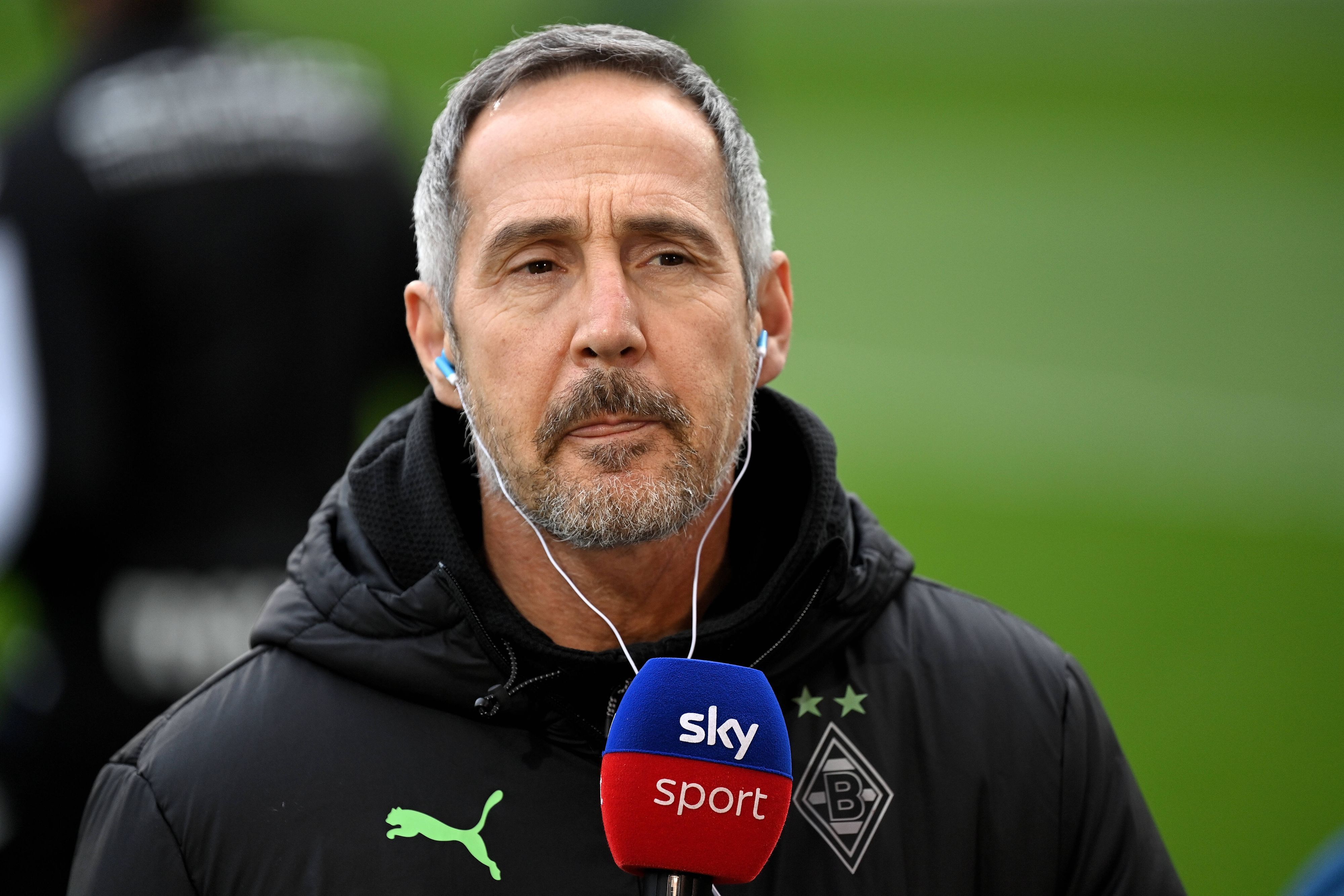 Gladbachs Cheftrainer Adi Hütter gibt am Rande des Bundesligaspiels bei Arminia Bielefeld am 5. Februar 2022 ein Interview. Hütter hat Kopfhörer im Ohr.