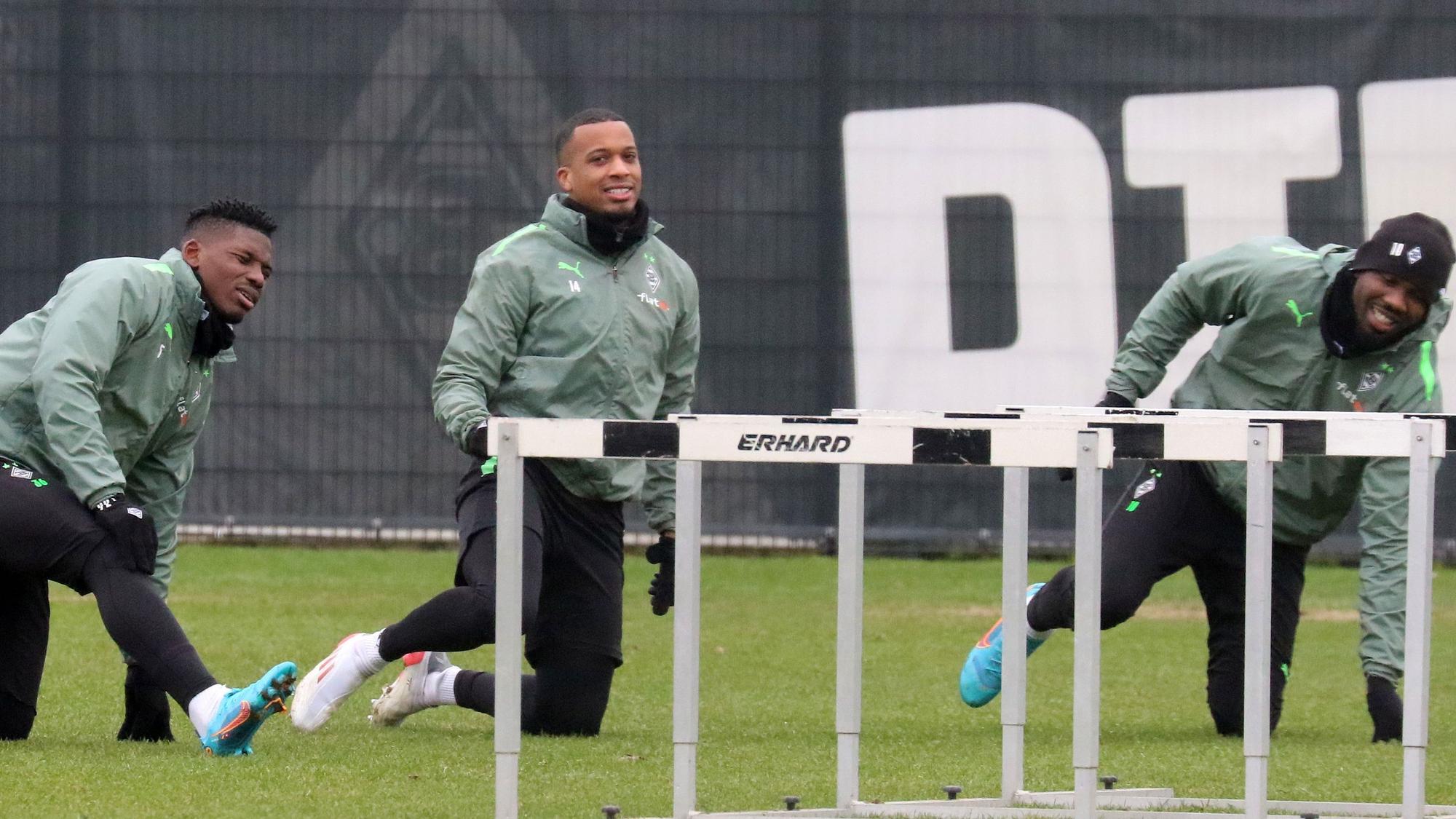 Gladbach-Stürmer unter sich: Alassane Plea (M.) mit Breel Embolo (l.) und Marcus Thuram (r.) beim Fohlen-Training am 8. Februar 2022 im Borussia-Park. Alle drei Spieler machen Aufwärmübungen.