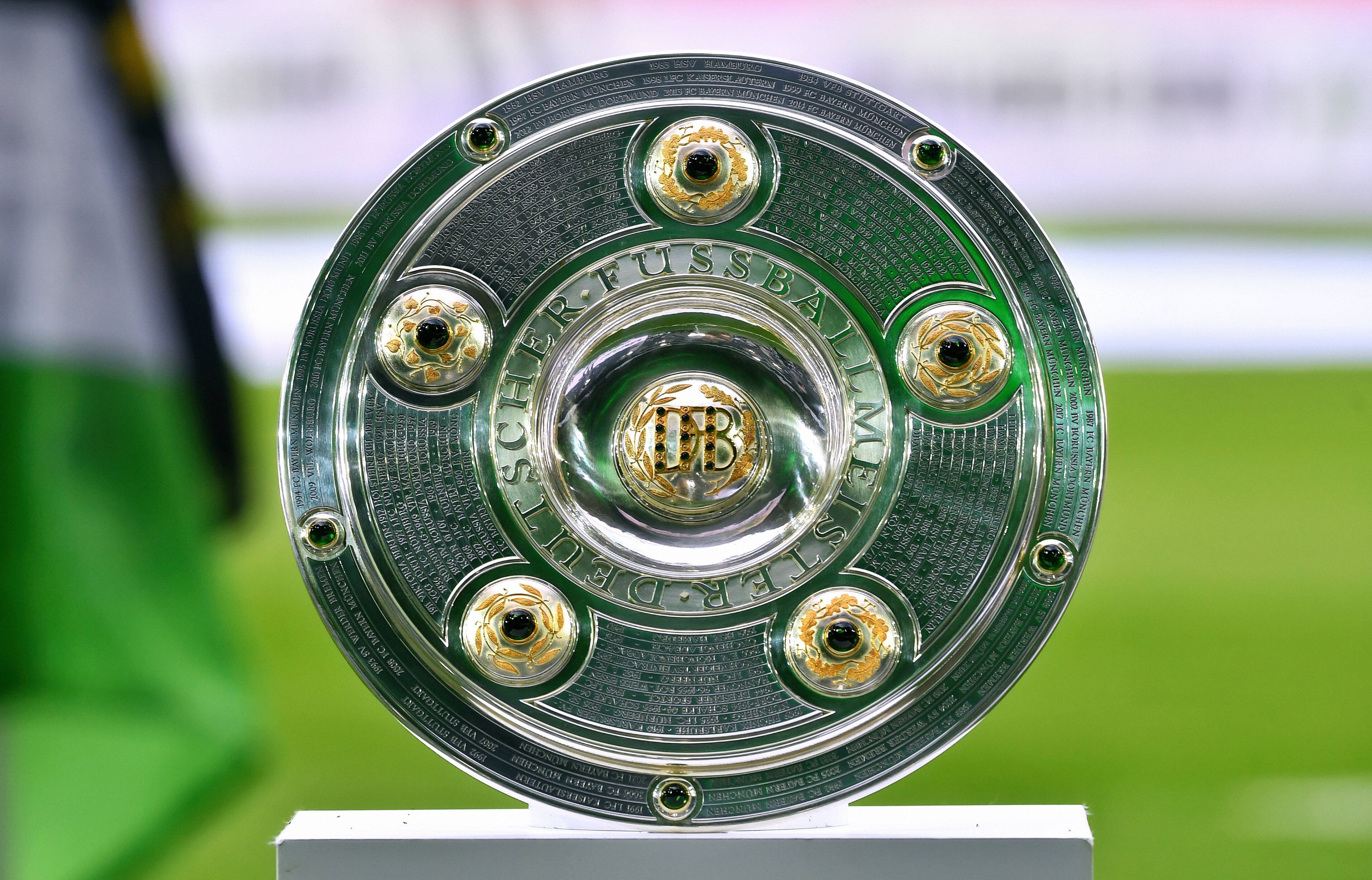 Die Meisterschale der Fußball-Bundesliga, hier zu sehen am 13. August 2021 im Gladbacher Borussia-Park. Im Hintergrund weht eine Fahne von Borussia Mönchengladbach.
