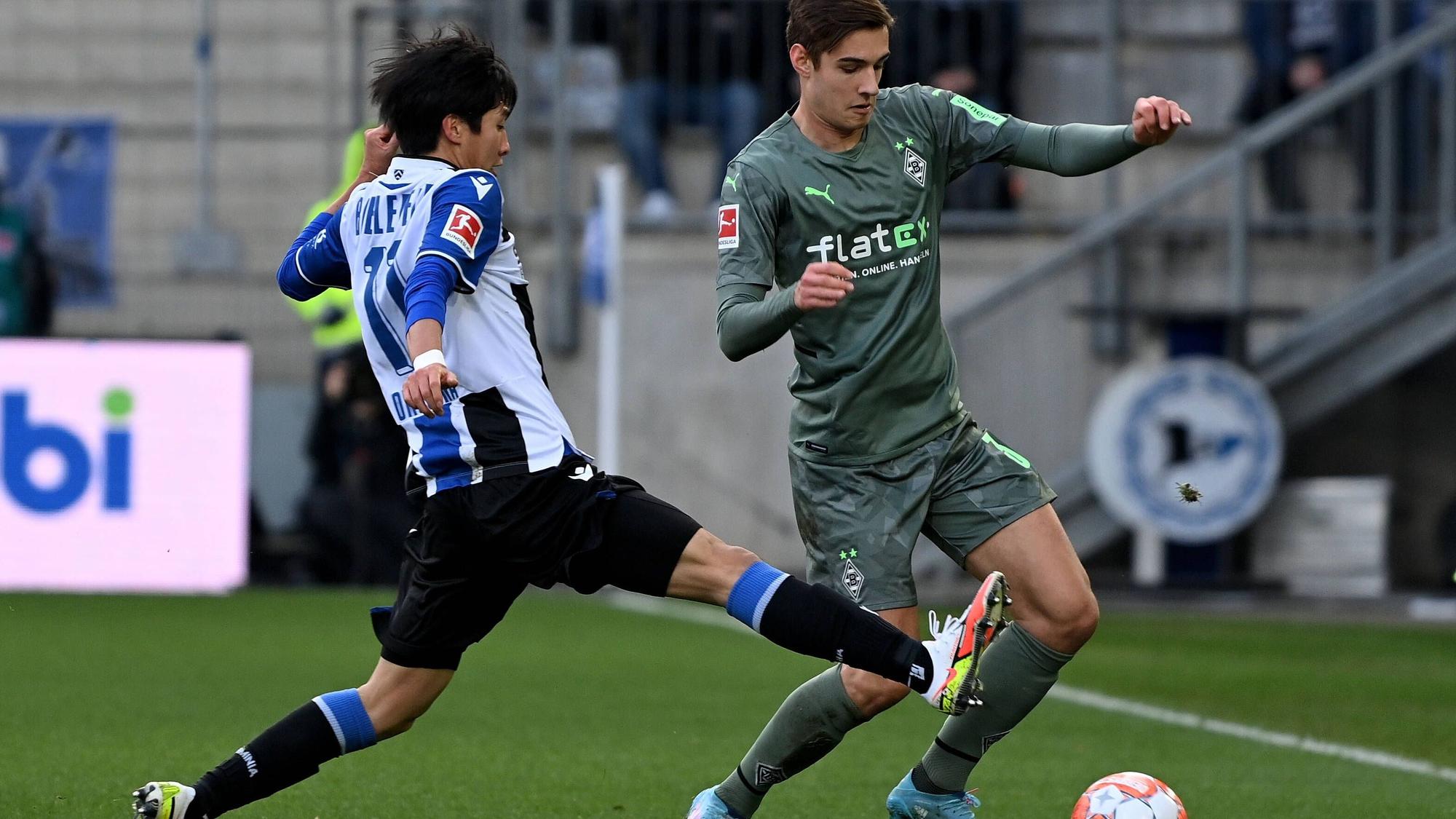 Florian Neuhaus (r.) kam im Bundesliga-Spiel zwischen Borussia Mönchengladbach und Arminia Bielefeld am 5. Februar 2022 zuletzt als Sechser zum Einsatz. Das Foto zeigt ihn ihm Zweikampf mit Masaya Okugawa (l.).