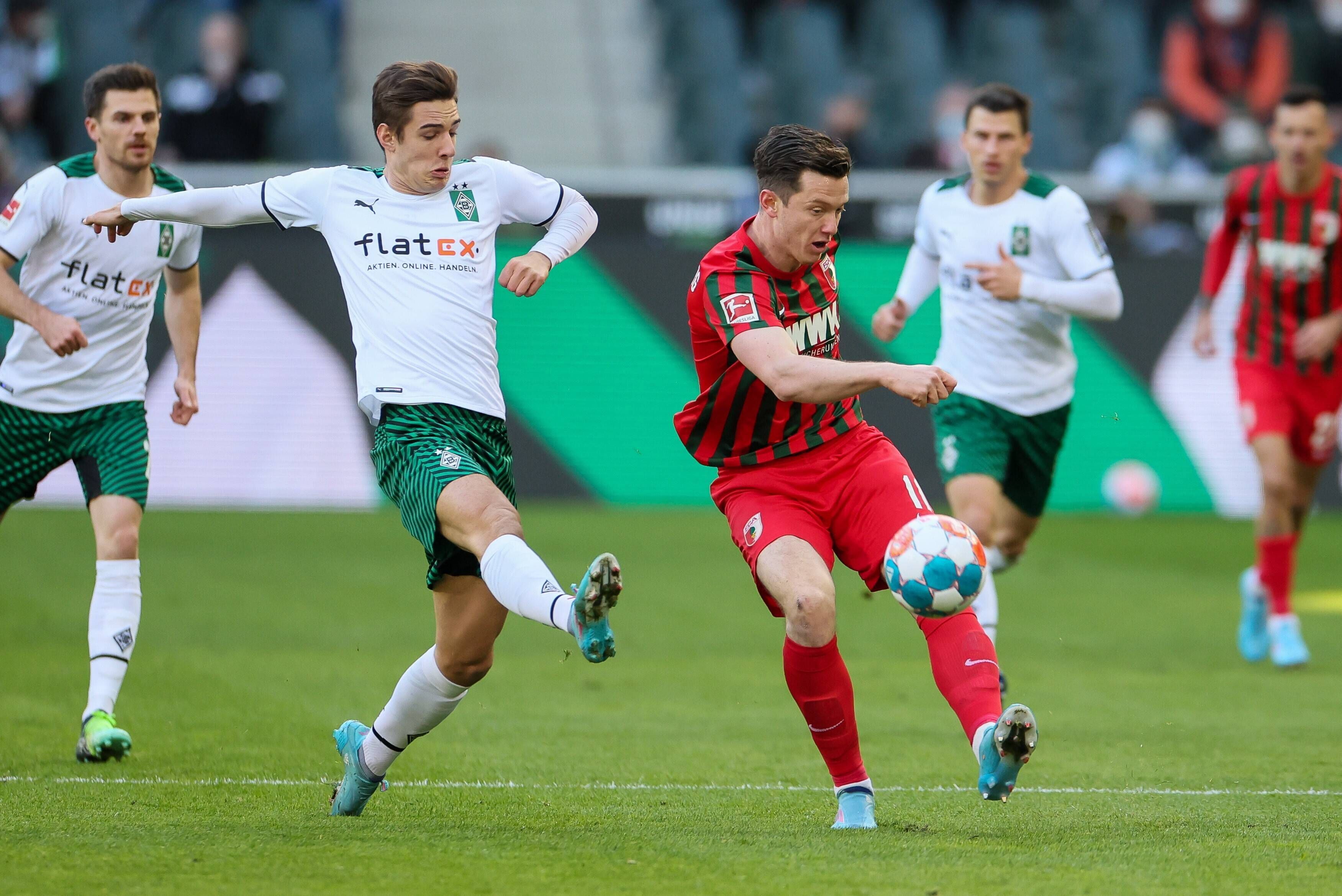 Borussia Mönchengladbach hat am Samstag (12. Februar 2022) den FC Augsburg mit 3:2 besiegt. Das Foto zeigt Borussias Florian Neuhaus beim Duell mit Augsburgs Michael Gregoritsch (r.).