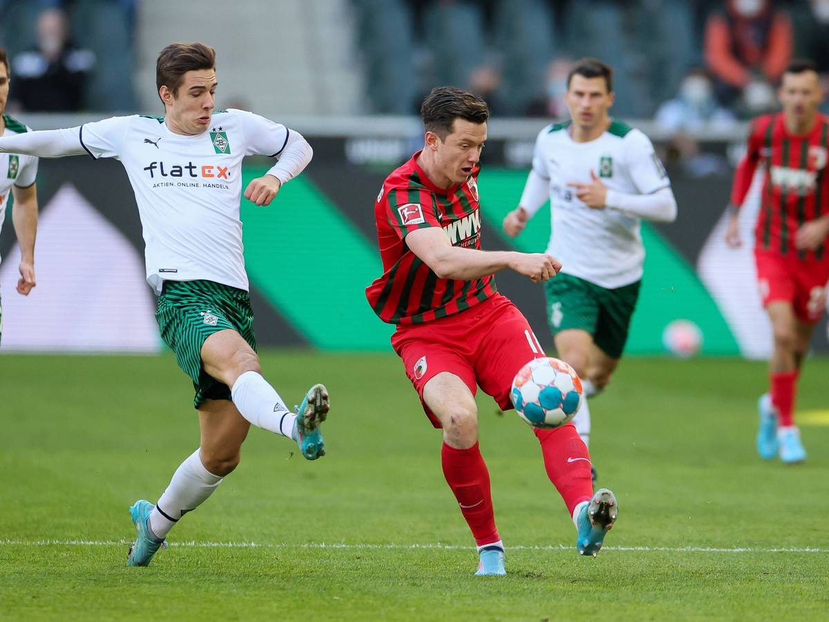 Borussia Mönchengladbach hat am Samstag (12. Februar 2022) den FC Augsburg mit 3:2 besiegt. Das Foto zeigt Borussias Florian Neuhaus beim Duell mit Augsburgs Michael Gregoritsch (r.).