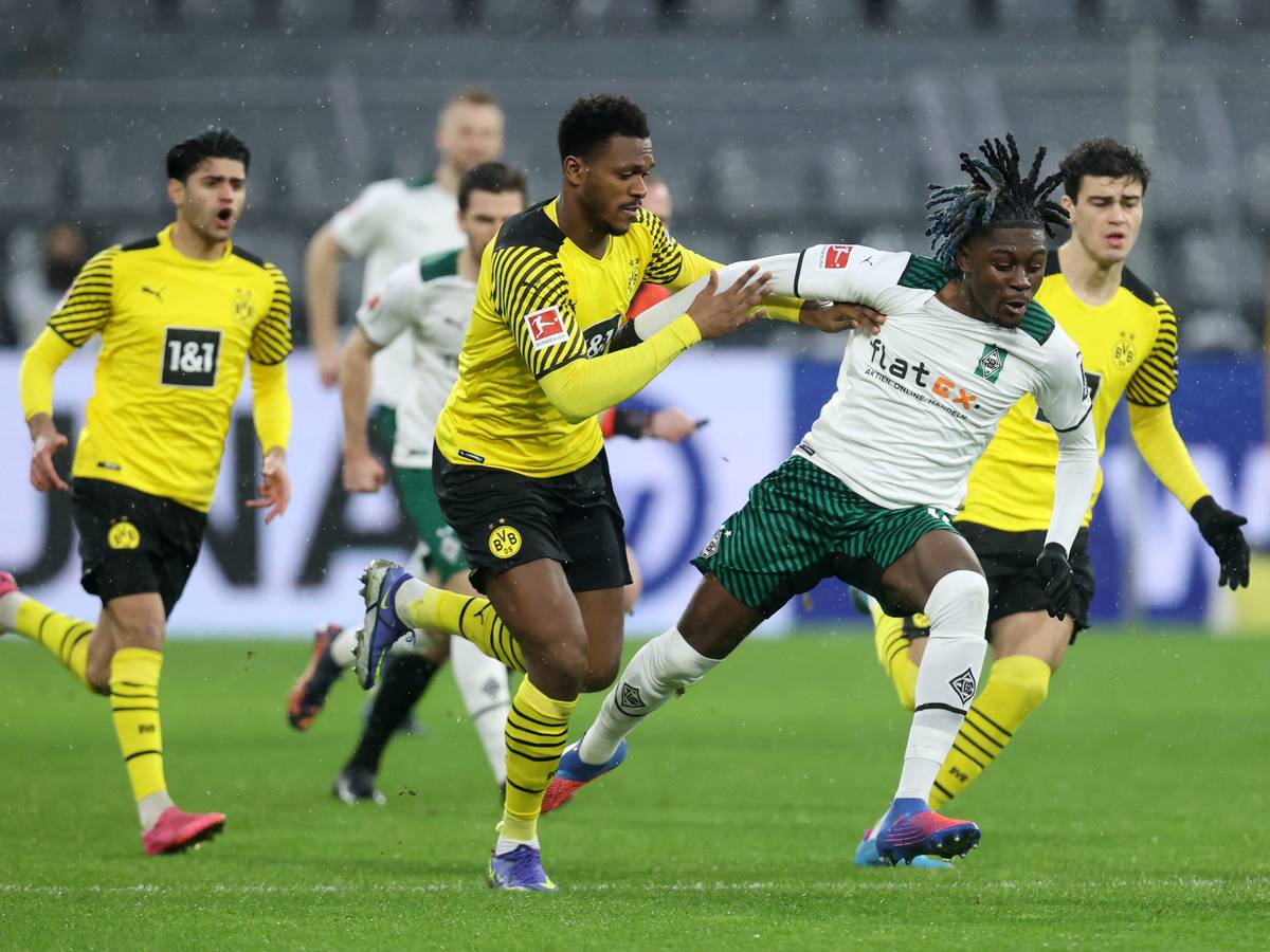 DORTMUND, GERMANY - FEBRUARY 20: Dan-Axel Zagadou of Borussia Dortmund battles for possession with Kouadio Kone of Borussia Monchengladbach during the Bundesliga match between Borussia Dortmund and Borussia Mönchengladbach at Signal Iduna Park on February 20, 2022 in Dortmund, Germany. (Photo by Alex Grimm/Getty Images)