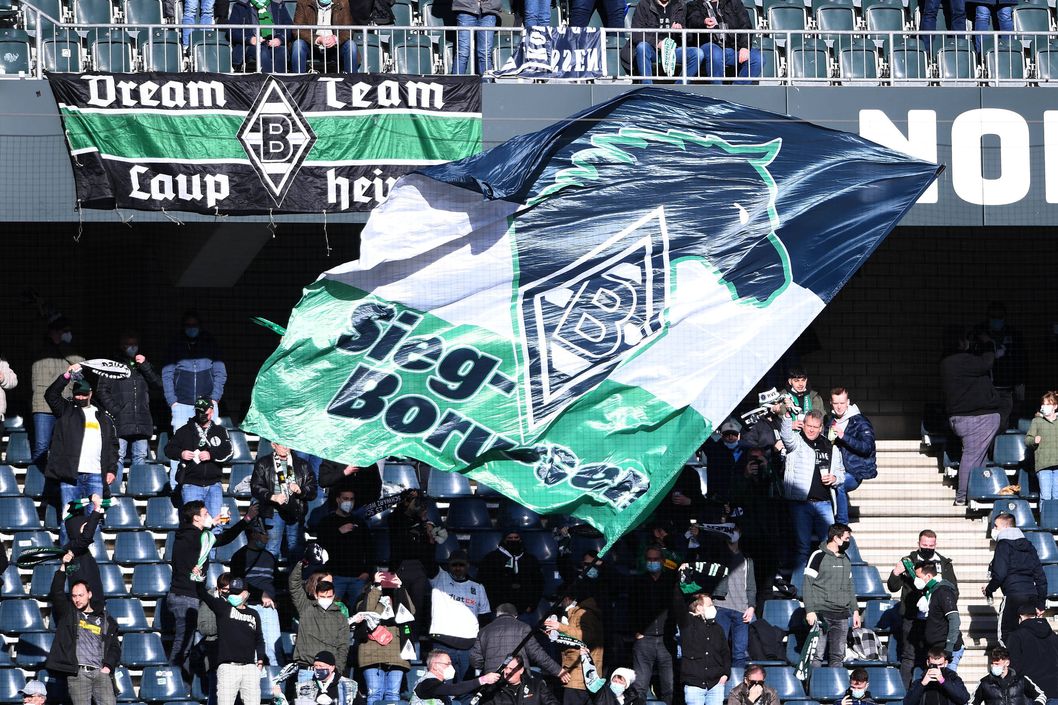 Fans von Borussia Mönchengladbach, hier zu sehen am 12. Februar 2022 im Borussia-Park beim Bundesliga-Duell gegen den FC Augsburg. Die Fans schwenken eine große Fahne.