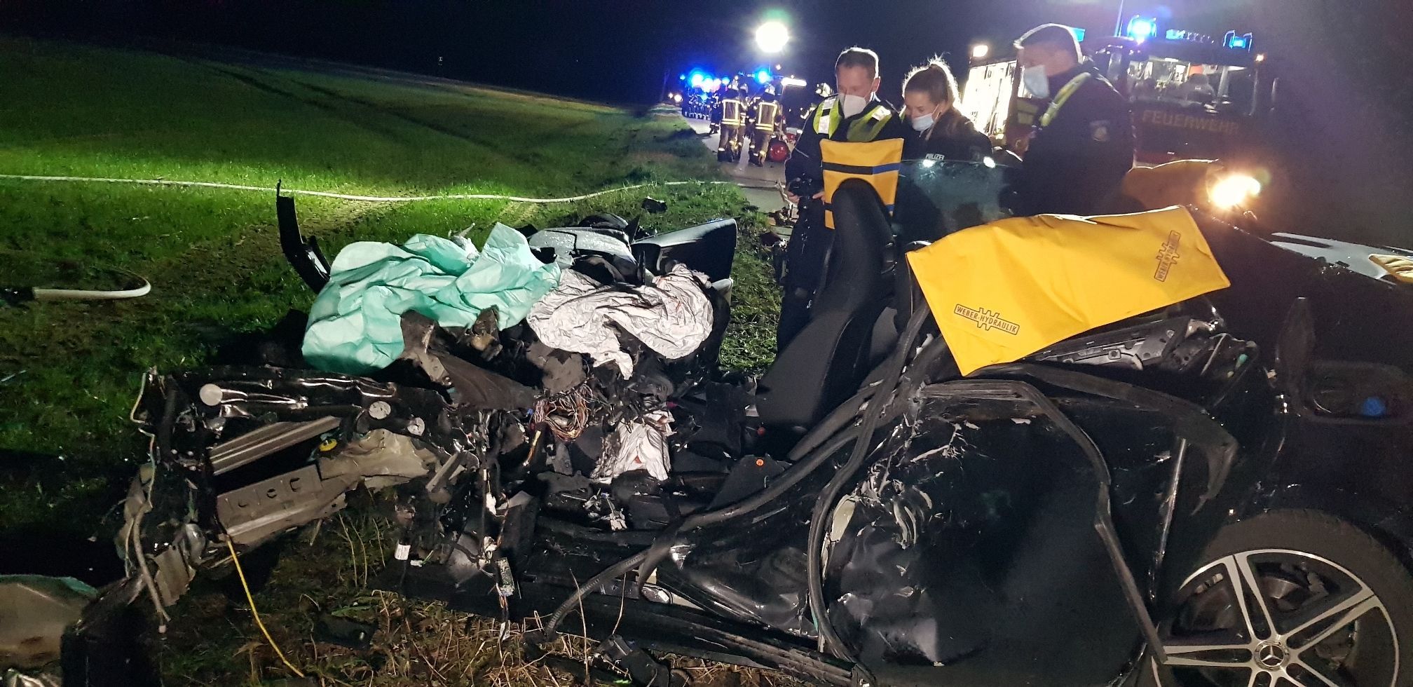 Polizisten schauen sich am 24. Februar 2022 auf der Bundesstraße 221 das zerstörte Auto nach einem Zusammenstoß mit einem Lkw an. Der vordere Teil des Fahrzeuges ist völlig zusammengepresst.