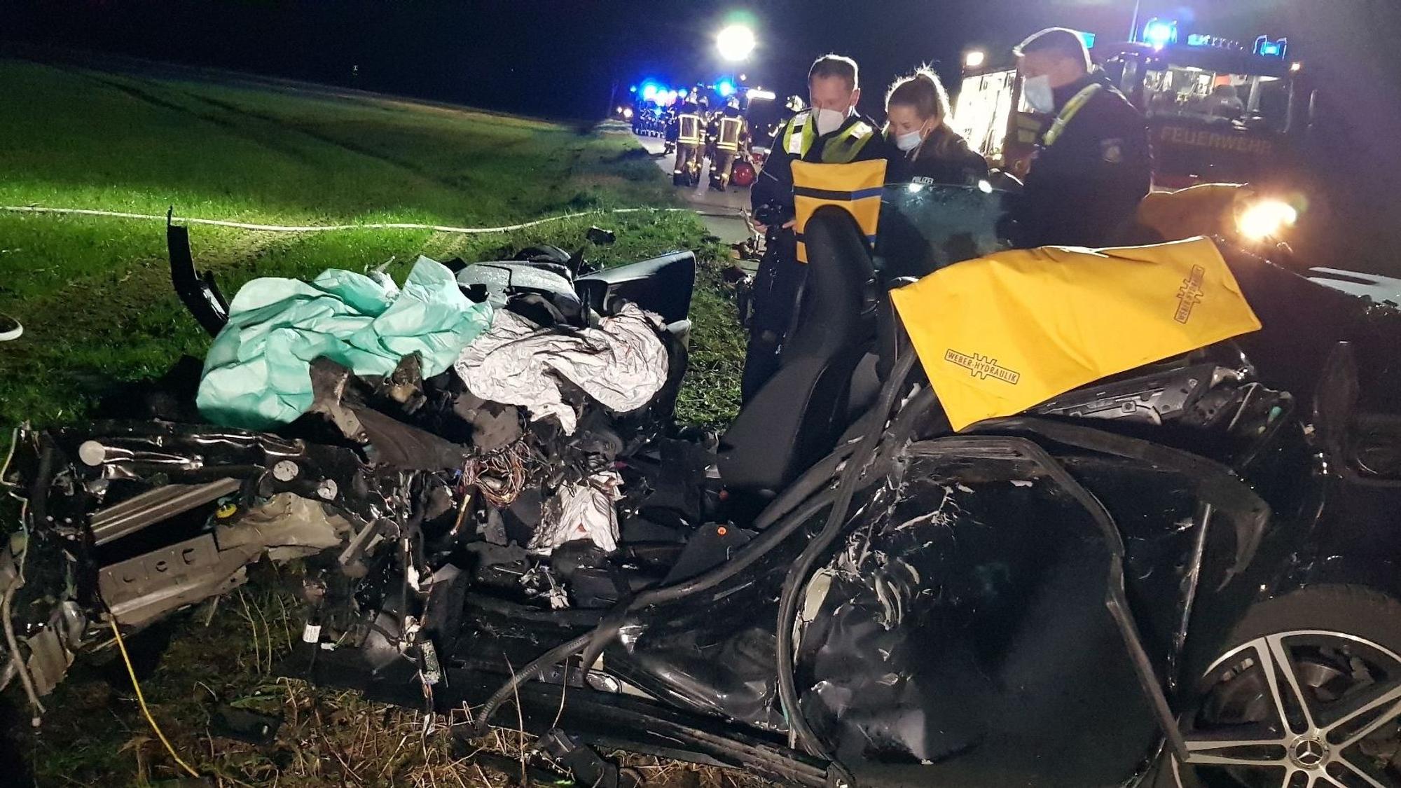 Polizisten schauen sich am 24. Februar 2022 auf der Bundesstraße 221 das zerstörte Auto nach einem Zusammenstoß mit einem Lkw an. Der vordere Teil des Fahrzeuges ist völlig zusammengepresst.