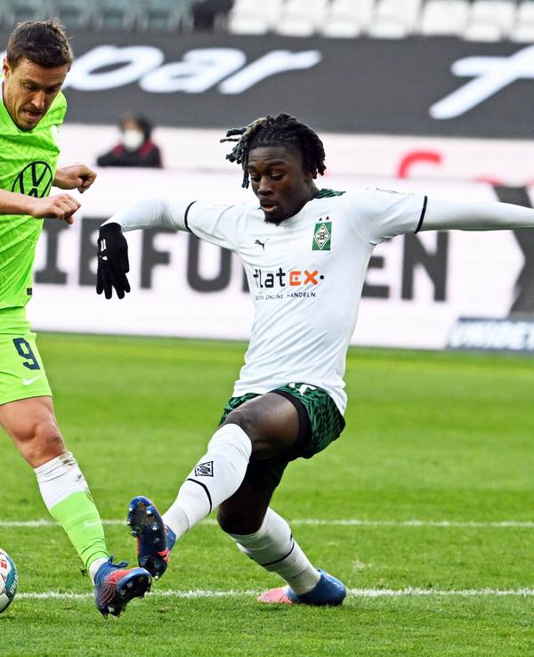 Manu Koné (r.) von Borussia Mönchengladbach im Zweikampf mit Max Kruse (l.) vom VfL Wolfsburg während des Bundesliga-Duells.