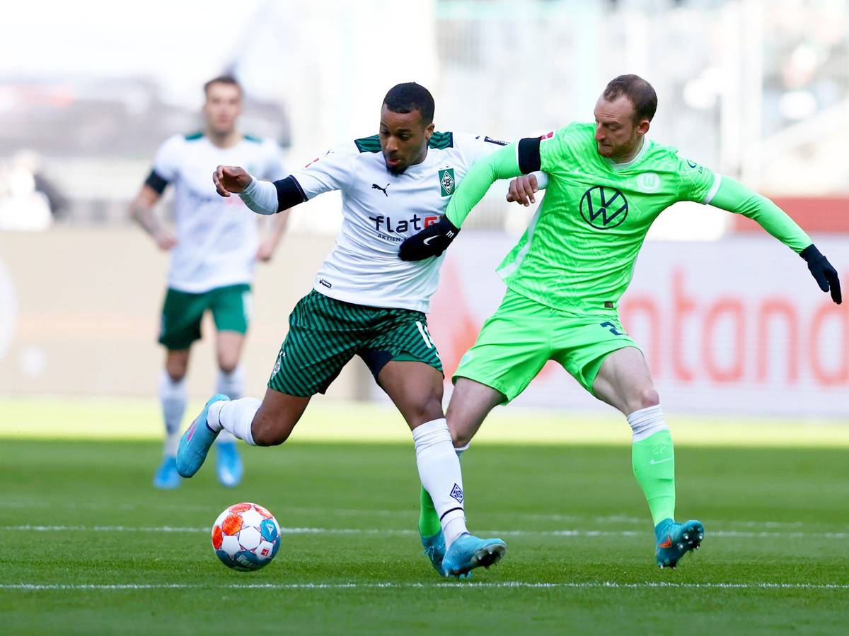 Bundesligist Borussia Mönchengladbach trifft am heutigen Samstag (26. Februar 2022) im heimischen Borussia-Park auf den VfL Wolfsburg. Das Foto zeigt Gladbachs Alassane Plea (l.) im Zweikampf mit Wolfsburgs Maximilian Arnold (r.). Beide kämpfen um den Ball.
