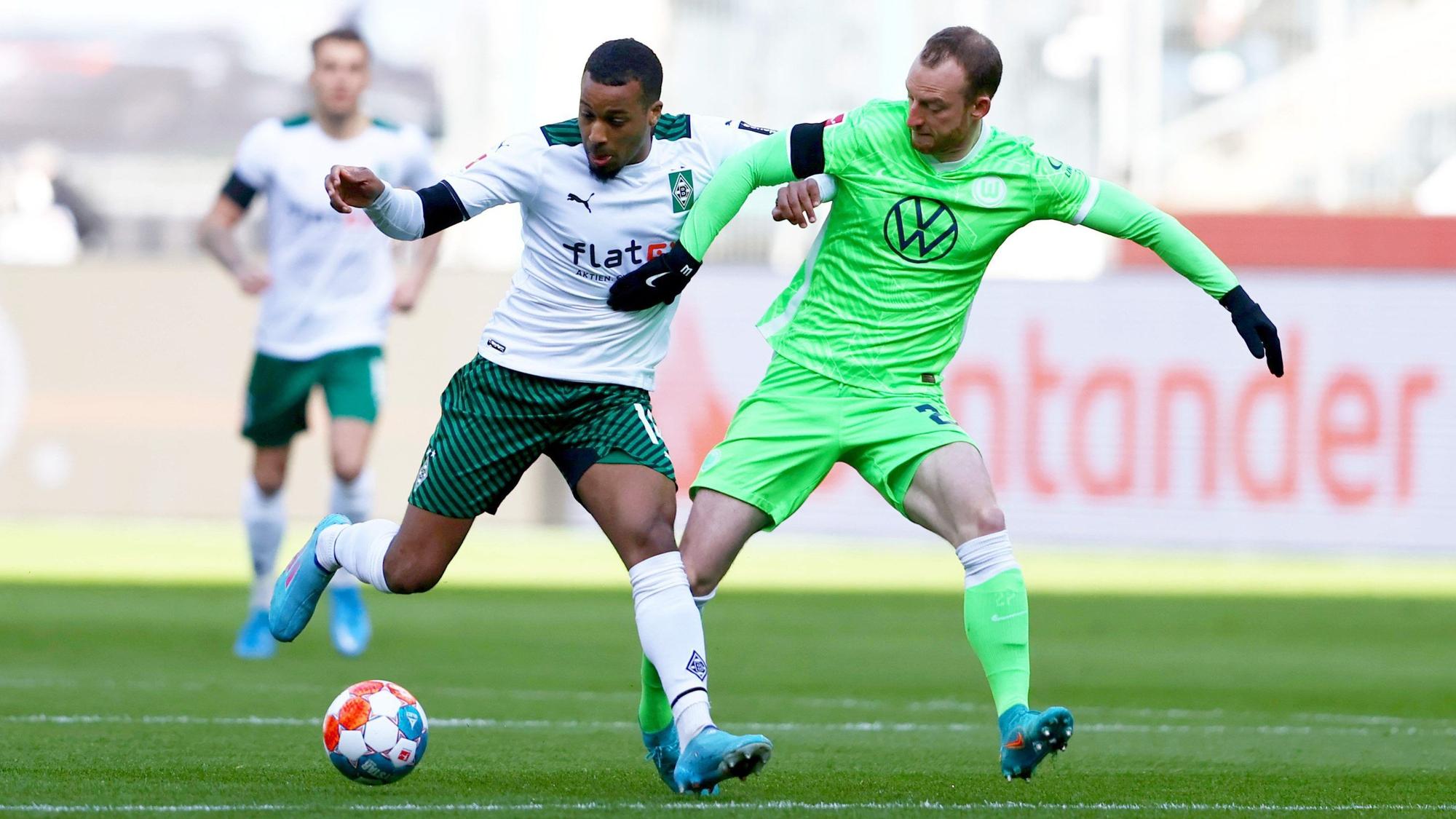 Bundesligist Borussia Mönchengladbach trifft am heutigen Samstag (26. Februar 2022) im heimischen Borussia-Park auf den VfL Wolfsburg. Das Foto zeigt Gladbachs Alassane Plea (l.) im Zweikampf mit Wolfsburgs Maximilian Arnold (r.). Beide kämpfen um den Ball.