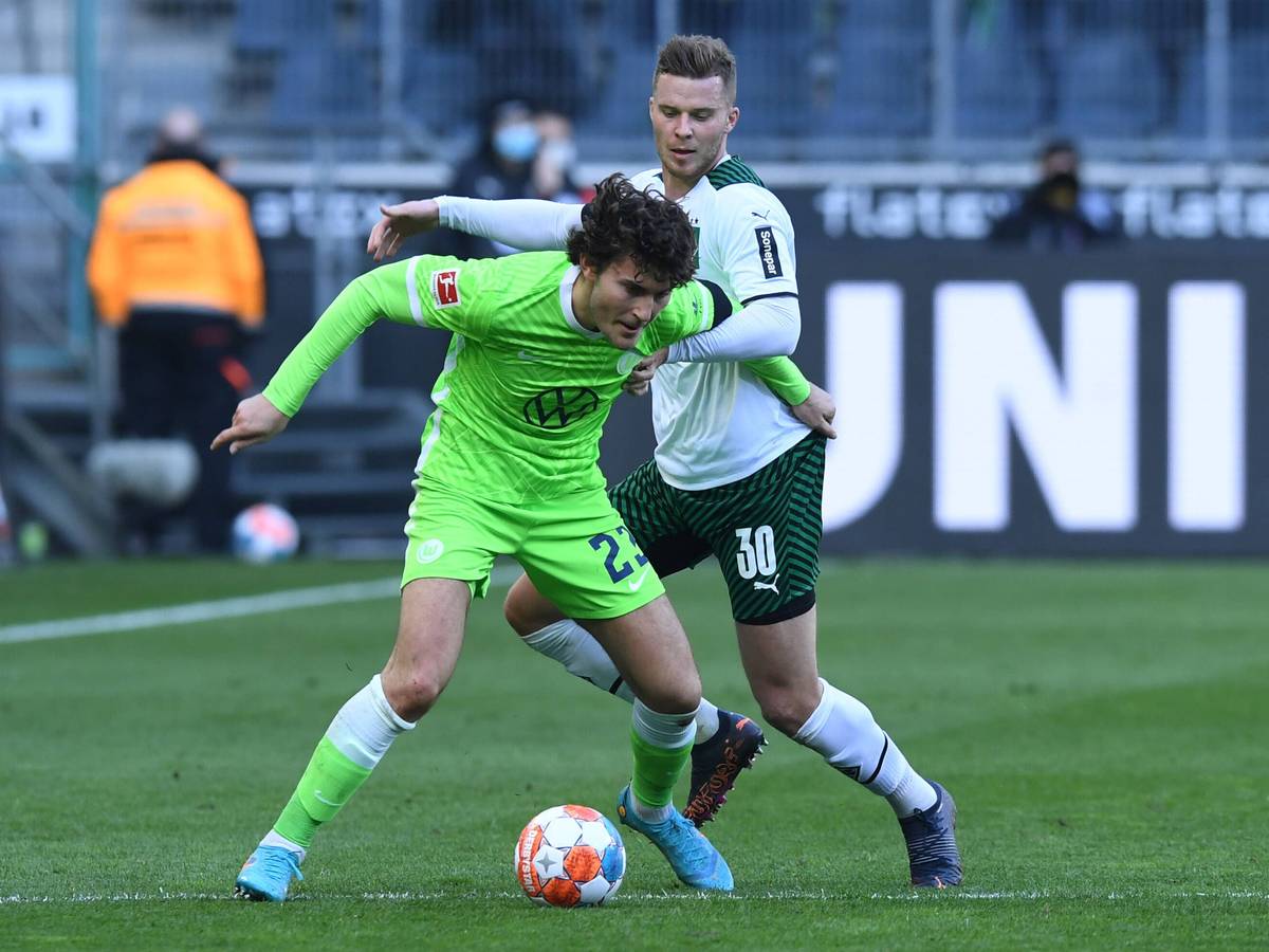 Nico Elvedi, Abwehrspieler von Borussia Mönchengladbach, im Zweikampf mit Wolfsburg-Profi Jonas Wind während des Bundesliga-Duells am 26. Februar 2022 im Borussia-Park. Wind schirmt den Ball ab.