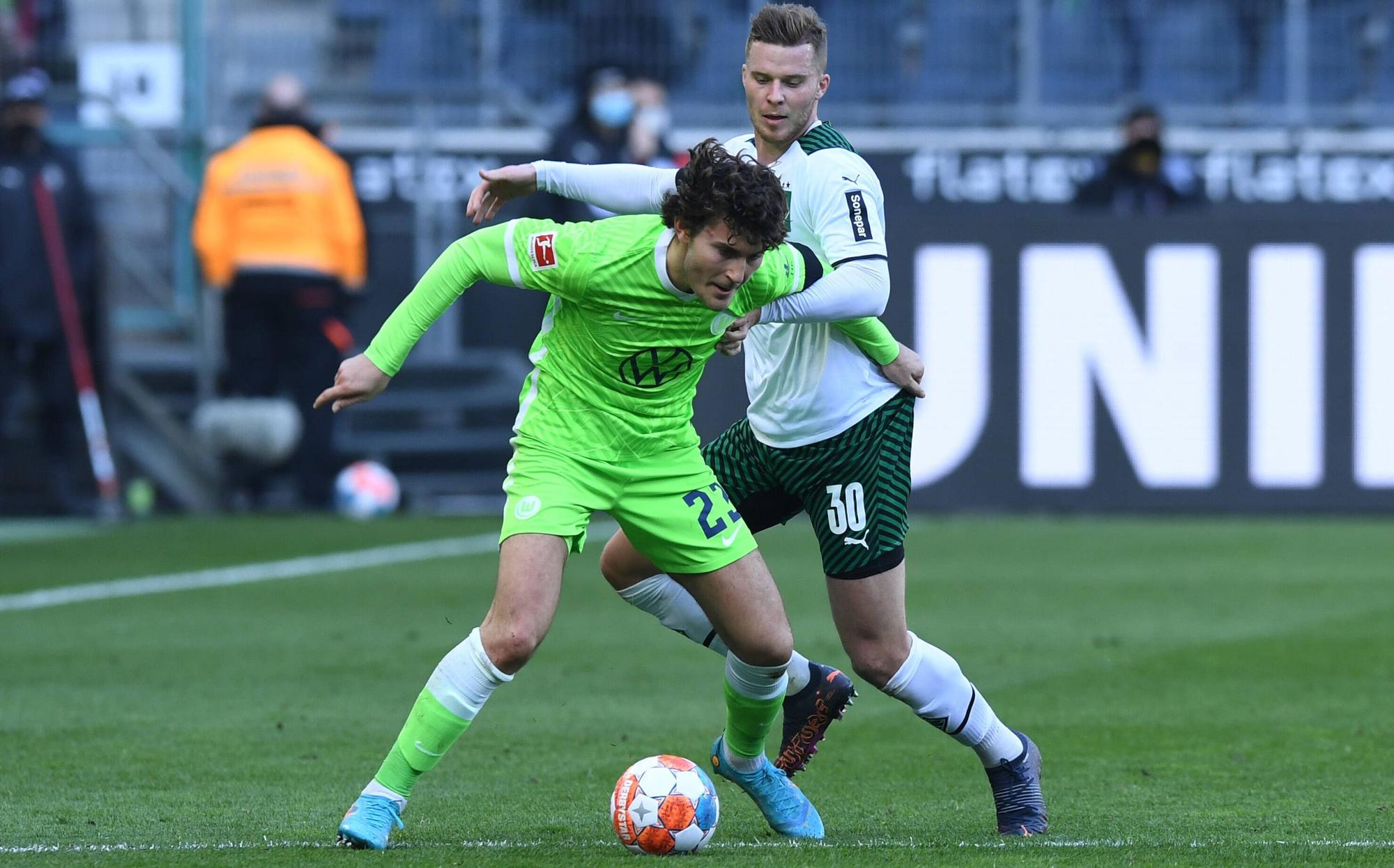 Nico Elvedi, Abwehrspieler von Borussia Mönchengladbach, im Zweikampf mit Wolfsburg-Profi Jonas Wind während des Bundesliga-Duells am 26. Februar 2022 im Borussia-Park. Wind schirmt den Ball ab.