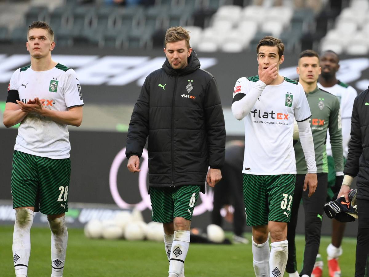 Matthias Ginter , Christoph Kramer und Florian Neuhaus von Borussia Moenchengladbach am 26.02.2022 nach dem Spiel gegen den VfL Wolfsburg mit hängenden Köpfen beim Applaudieren der Fans.