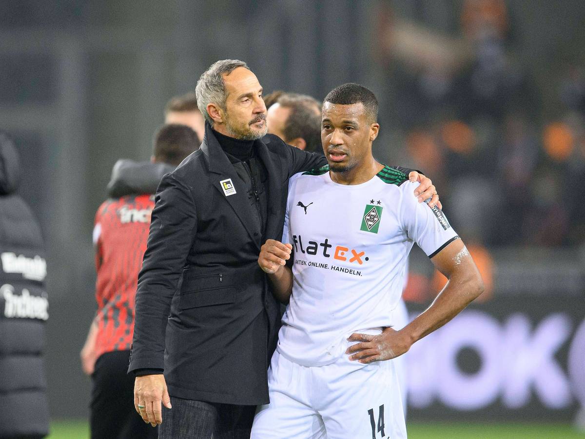 Adi Hütter (l.),Trainer von Borussia Mönchengladbach, tröstet Torjäger Alassane Plea (r.) nach dem Spiel gegen Eintracht Frankfurt am 15.12.2021 im Borussia-Park.