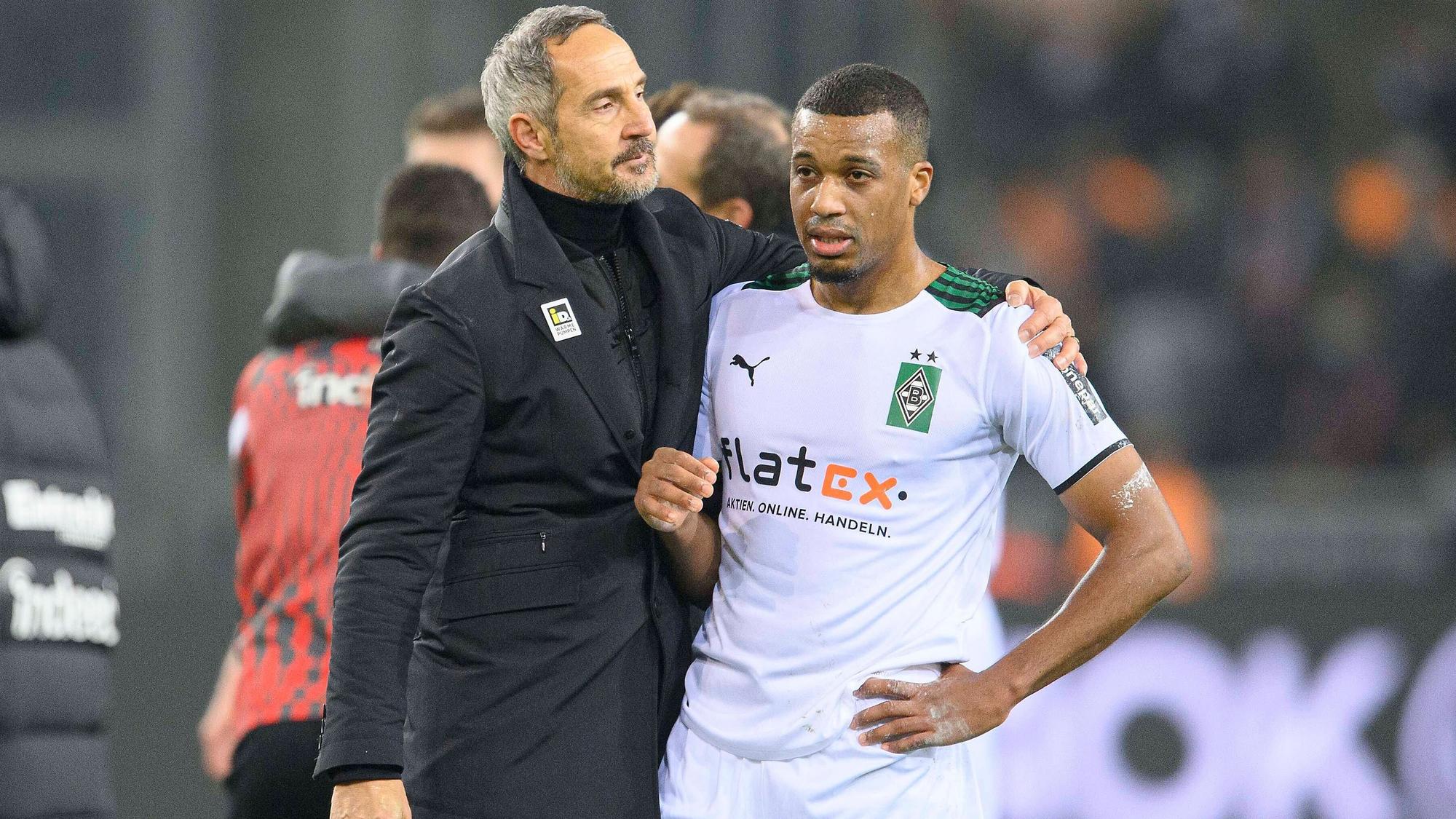 Adi Hütter (l.),Trainer von Borussia Mönchengladbach, tröstet Torjäger Alassane Plea (r.) nach dem Spiel gegen Eintracht Frankfurt am 15.12.2021 im Borussia-Park.