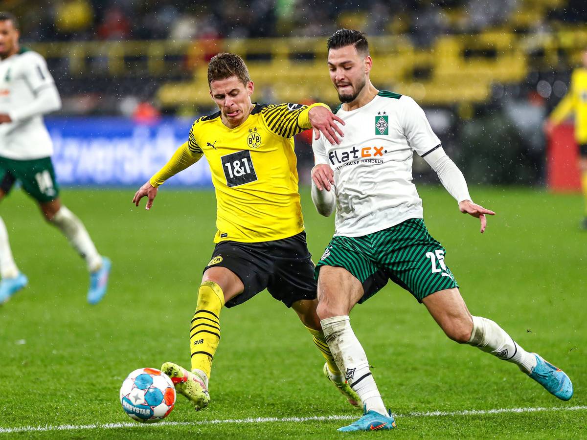 Der Ex-Gladbacher Thorgan Hazard (l.), hier im Trikot von Borussia Dortmund, liefert sich während des Bundesliga-Duells (20. Februar 2022) gegen Borussia Mönchengladbach einen Zweikampf mit Ramy Bensebaini (r.) im Signal-Iduna-Park. Beide Spieler wollen den Ball erobern.