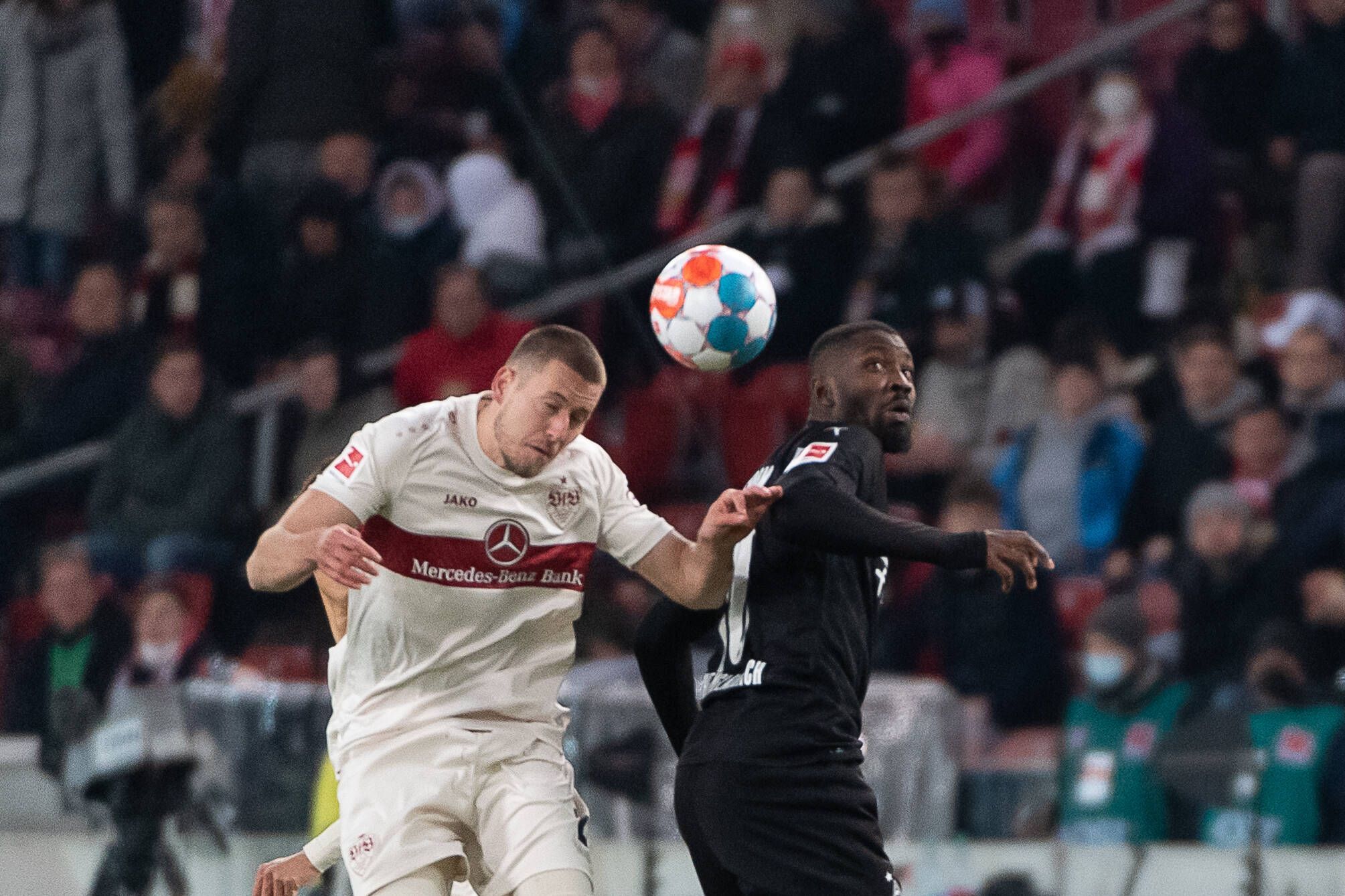 Gladbach-Stürmer Marcus Thuram (r,) im Kopfballduell mit Waldemar Anton (l.) vom VfB Stuttgart im Bundesliga-Duell am 5. März 2022 in der Mercedes-Benz-Arena. Beide Spieler schauen zum Ball.