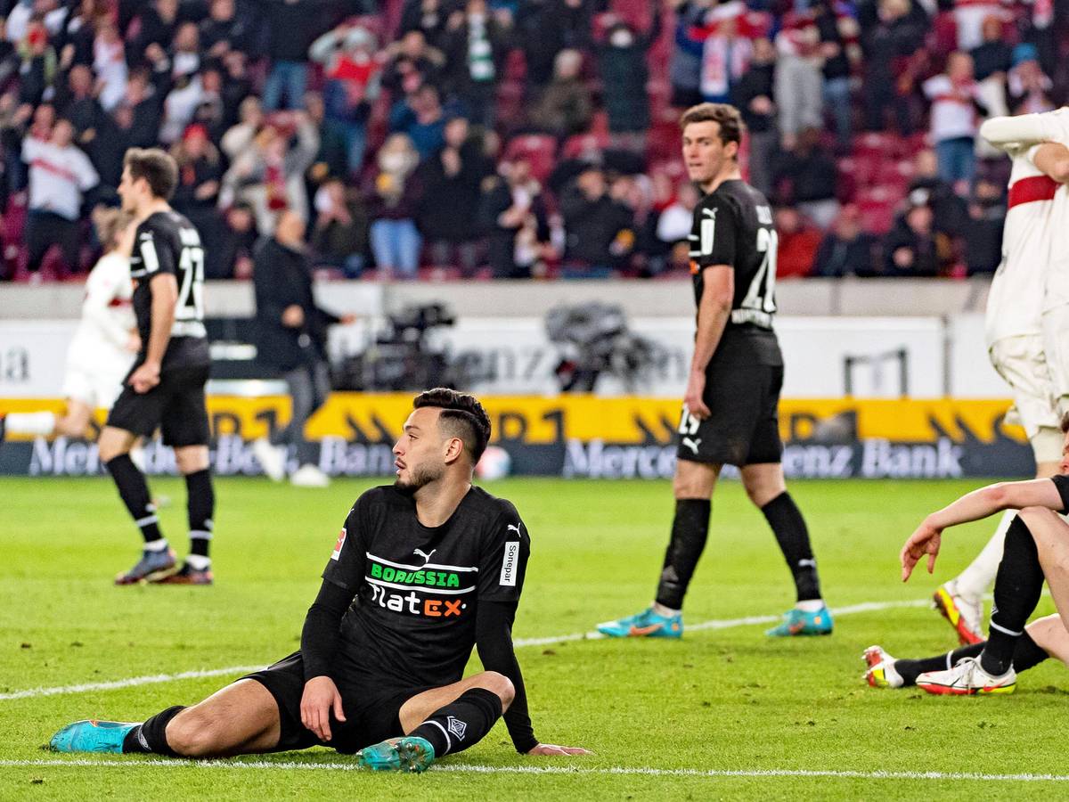 Jubelnde Stuttgarter, gefrustete Gladbach-Spieler wie Ramy Bensebaini (l.) oder Matthias Ginter (r.) beim Bundesliga-Duell am 5. März 2022 in der Mercedes-Benz-Arena. Bensebaini und Ginter sitzen enttäuscht auf dem Spielfeld.