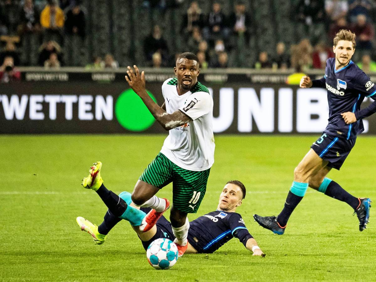 Gladbach-Stürmer Marcus Thuram (M.) setzt sich gegen zwei Berliner Gegenspieler im Bundesliga-Duell (12. März 2022) im Borussia-Park durch. Thuram schaut nach vorne.