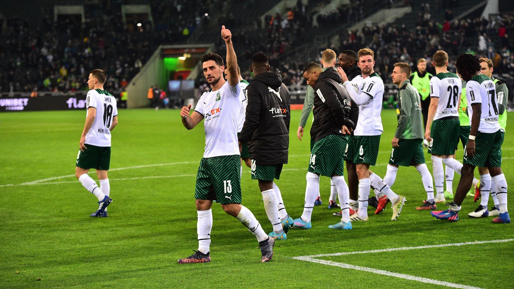 Die Spieler der Gladbacher Borussia drehen nach dem Heimdreier gegen Hertha BSC (12. März 2022) im Borussia-Park eine Ehrenrunde auf dem Spielfeld. Kapitän Lars Stindl macht die Dauem-Hoch-Geste Richtung Zuschauer.