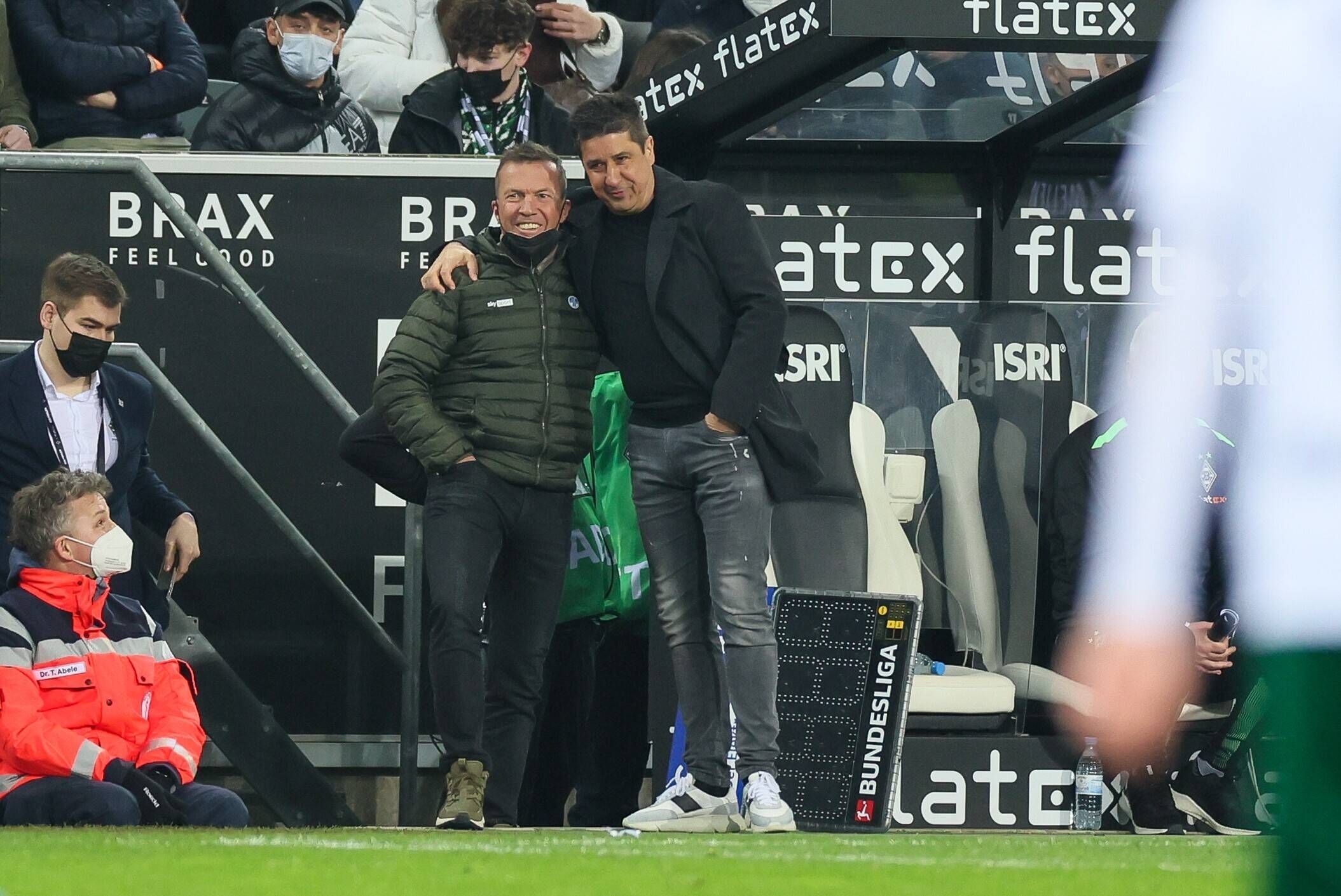 Fußballexperte Lothar Matthäus (l.) und Co-Trainer Christian Peintinger (r.) von Borussia Mönchengladbach umarmen sich beim Spiel gegen Hertha BSC am Samstag (12. März 2022) an der Seitenlinie.