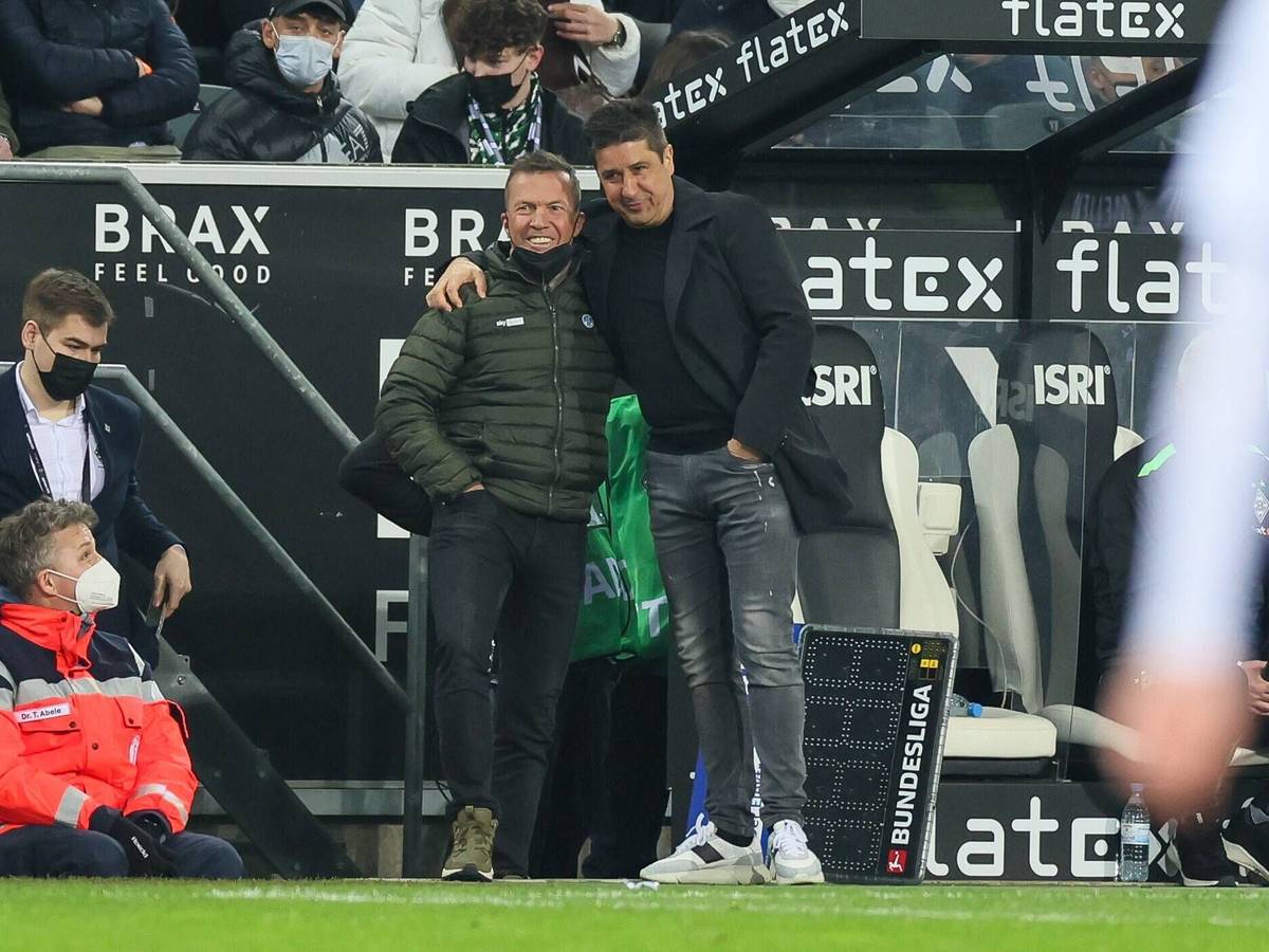 Fußballexperte Lothar Matthäus (l.) und Co-Trainer Christian Peintinger (r.) von Borussia Mönchengladbach umarmen sich beim Spiel gegen Hertha BSC am Samstag (12. März 2022) an der Seitenlinie.