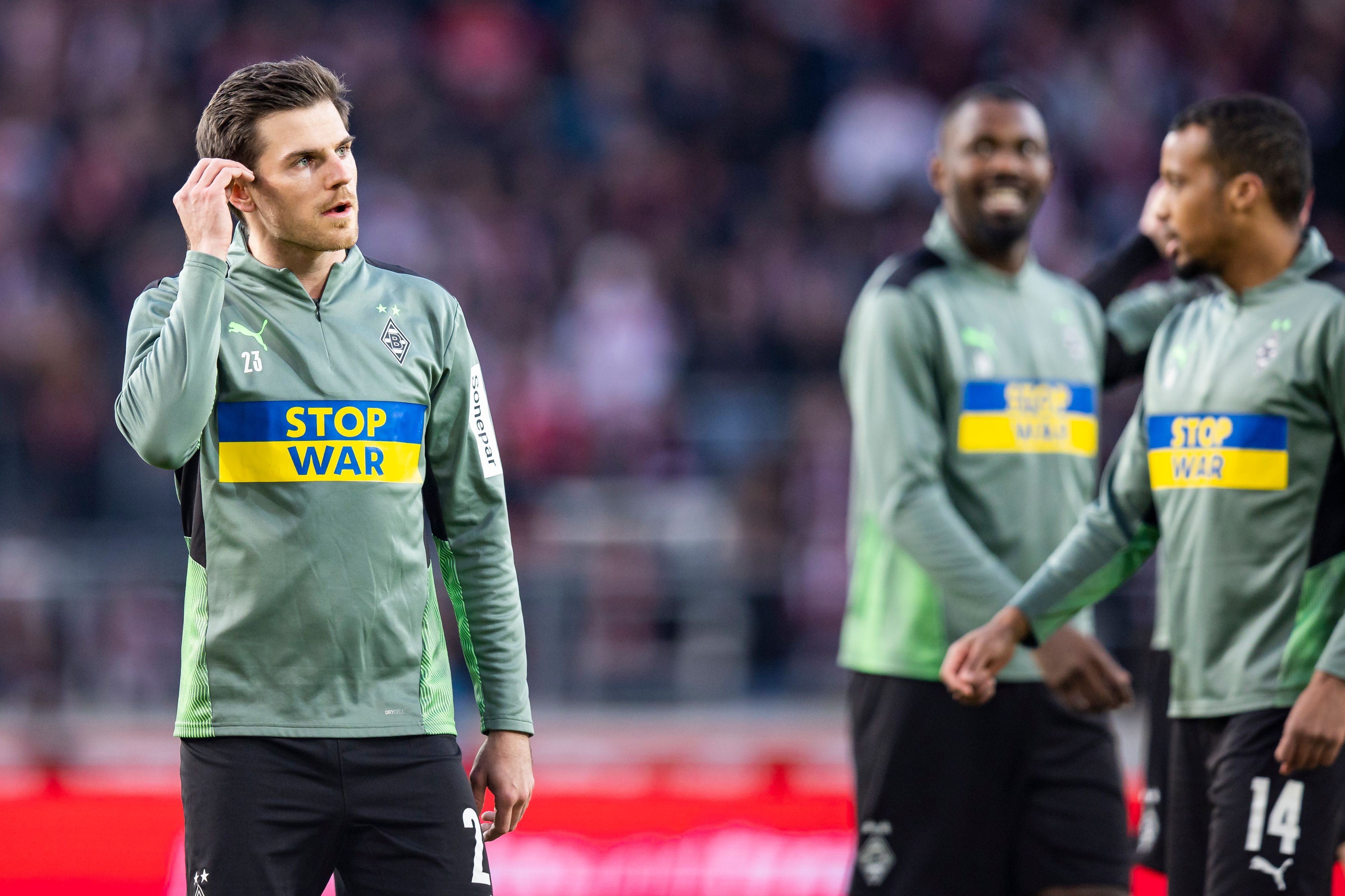 Gladbach-Profi Jonas Hofmann vor der Bundesliga-Partie der Borussia beim VfB Stuttgart am 6. März 2022. Hofmann steht beim Aufwärmen mit Sonder-Aufwärmtrikot und der Aufschrift «Stop War» und den Farben der Ukraine auf dem Platz.