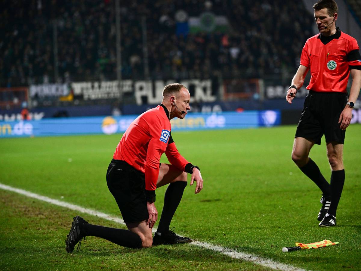 Schiedsrichter-Assistent Christian Gittelmann geht zu Boden, getroffen von einem Bierbecher im Bundesliga-Duell zwischen dem VfL Bochum und Borussia Mönchengladbach am 18, März 2022. Schiedsrichter Cortus kommt zu Hilfe.