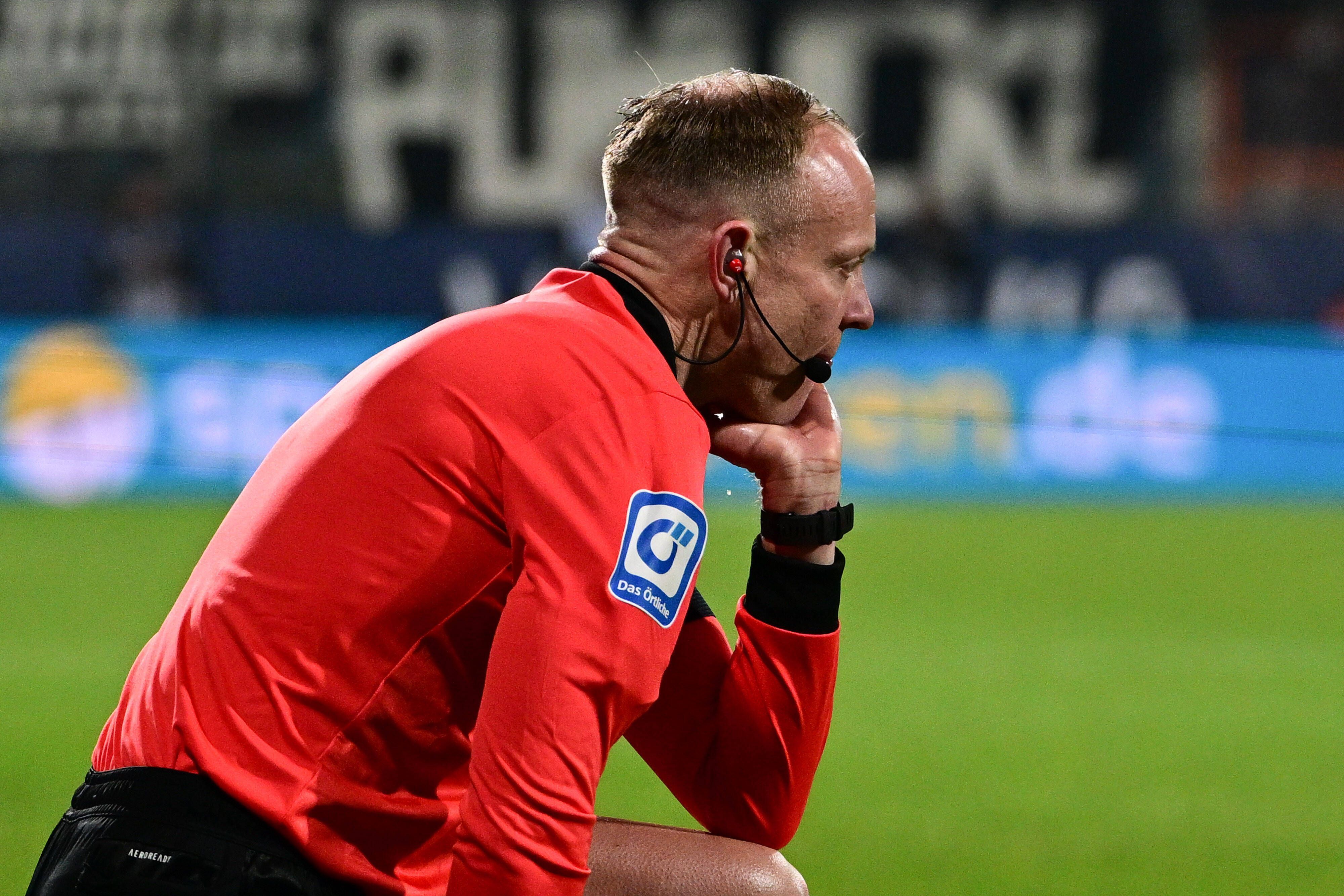 Linienrichter Christian Gittelmann sitzt benommen auf dem Spielfeld: Ihn hat beim Bundesliga-Match zwischen dem VfL Bochum und Borussia Mönchengladbach am Freitag (18. März 2022) ein Becher getroffen, woraufhin die Partie abgebrochen wurde.