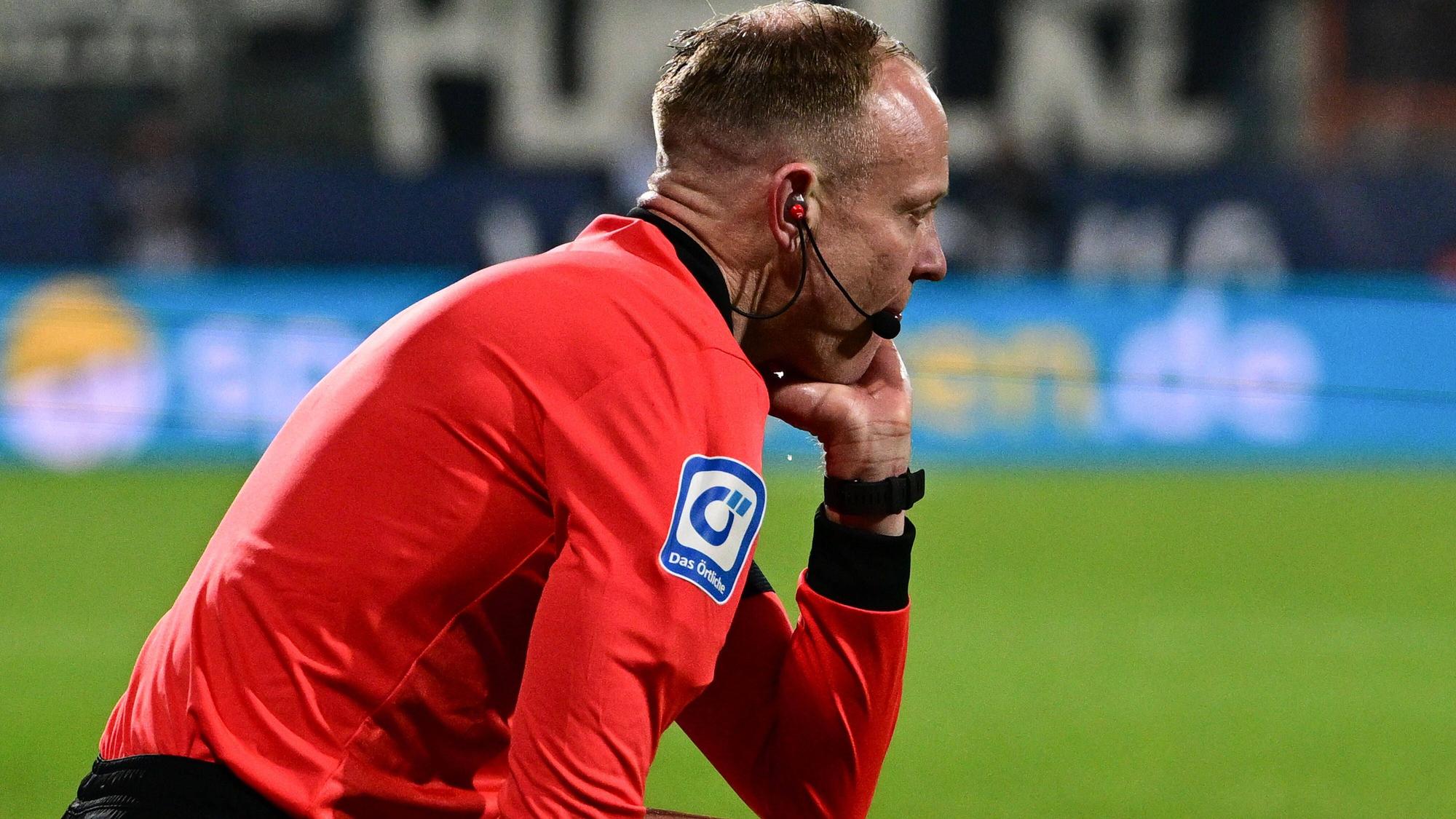 Linienrichter Christian Gittelmann sitzt benommen auf dem Spielfeld: Ihn hat beim Bundesliga-Match zwischen dem VfL Bochum und Borussia Mönchengladbach am Freitag (18. März 2022) ein Becher getroffen, woraufhin die Partie abgebrochen wurde.
