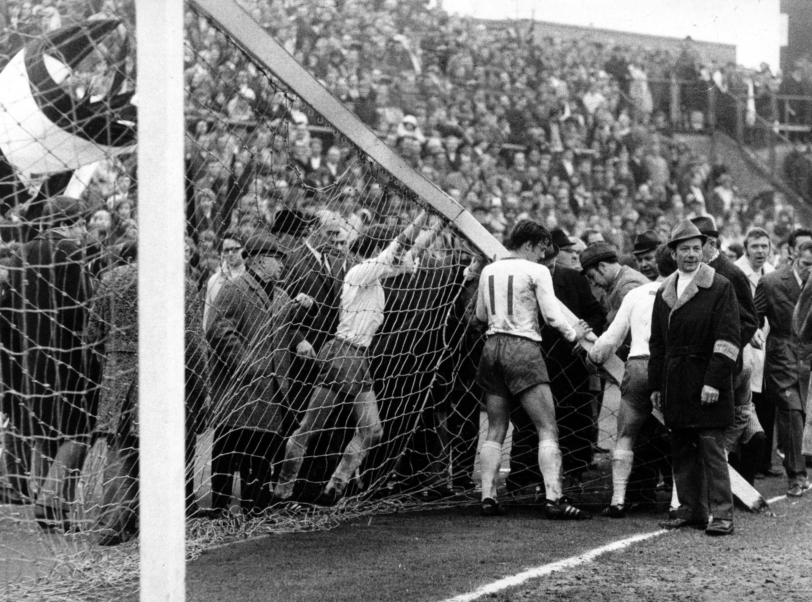 Am 3. April 1971 bricht bei der Bundesliga-Partie zwischen Borussia Mönchengladbach und dem SV Werder Bremen auf dem Gladbacher Bökelberg der Torpfosten. Auf diesem Foto versuchen Bremer Spieler, dass Tor wieder aufzurichten. Sie drücken und schieben.